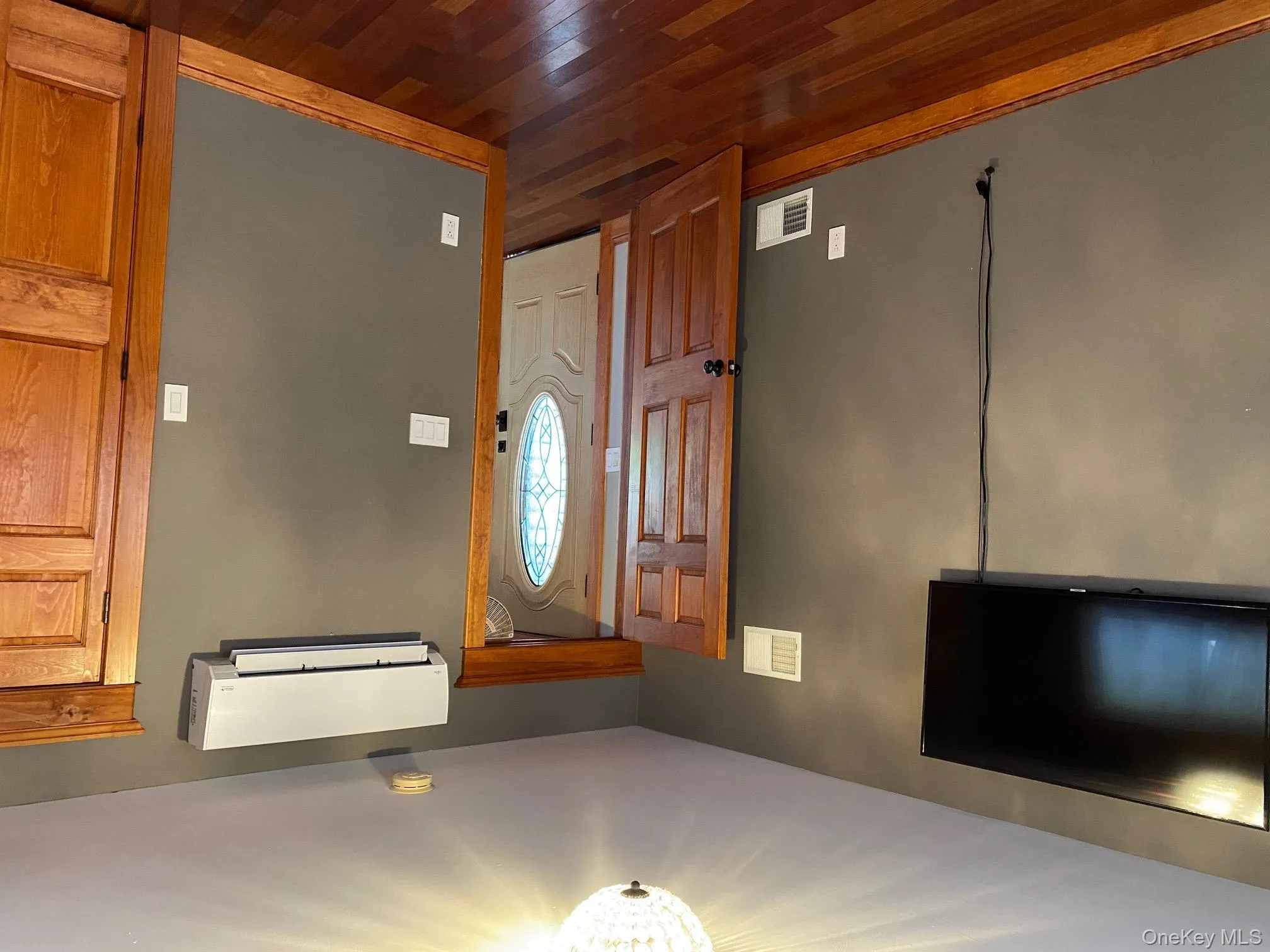 Entryway featuring dark wood finished floors and an AC wall unit Entryway featuring dark wood finished floors and an AC wall unit