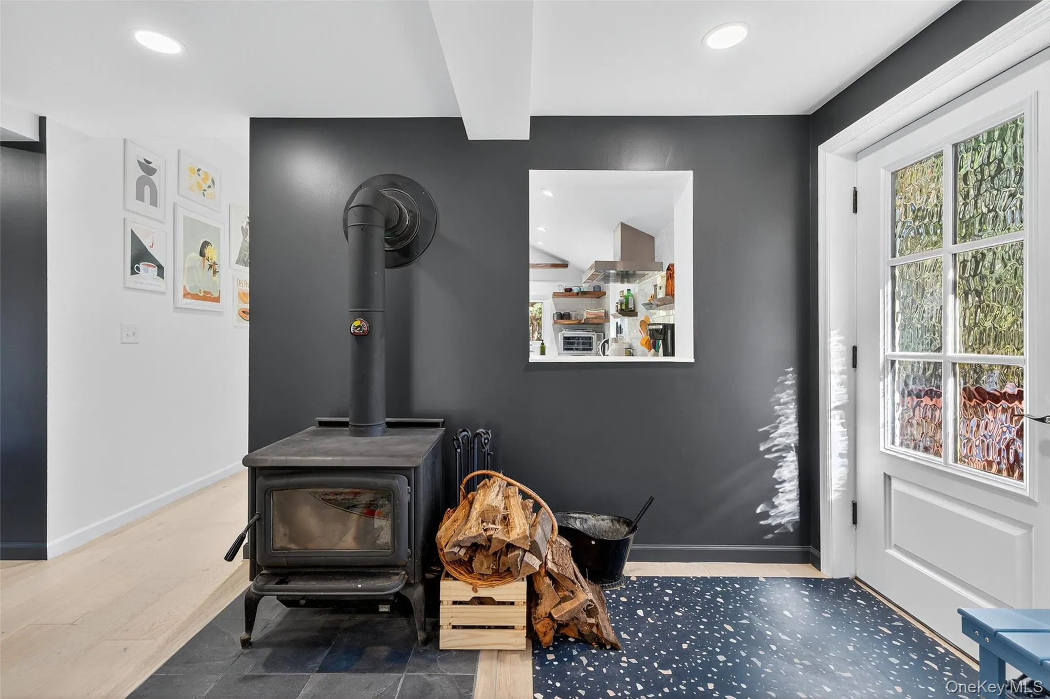 View of wood-burning stove and pass-through window to kitchen View of wood-burning stove and pass-through window to kitchen