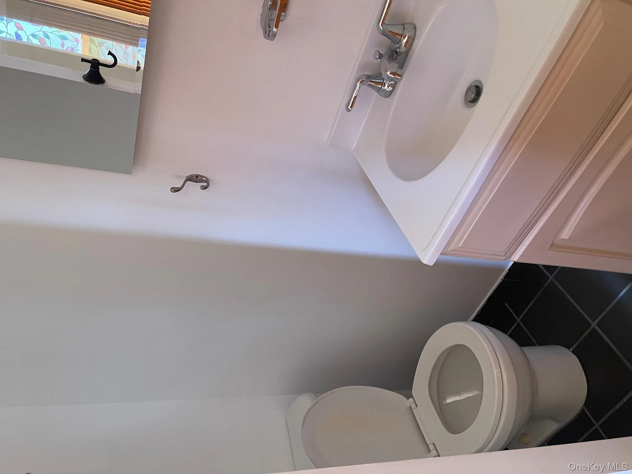 Bathroom with dark tile patterned flooring and vanity Bathroom with dark tile patterned flooring and vanity