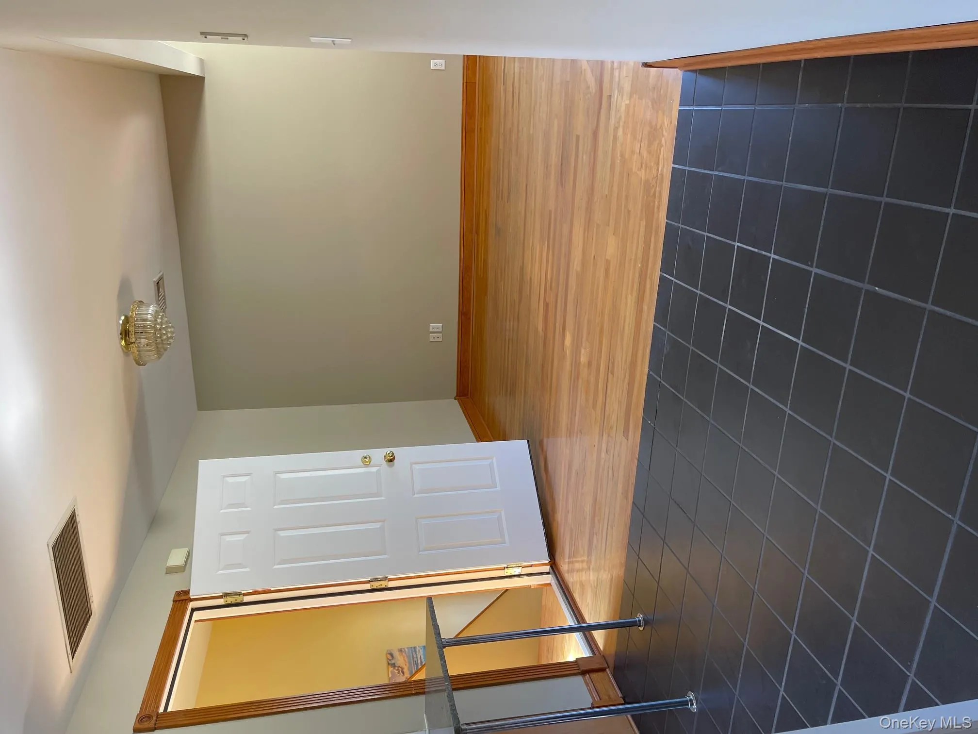 Empty room featuring dark tile patterned flooring and a chandelier Empty room featuring dark tile patterned flooring and a chandelier