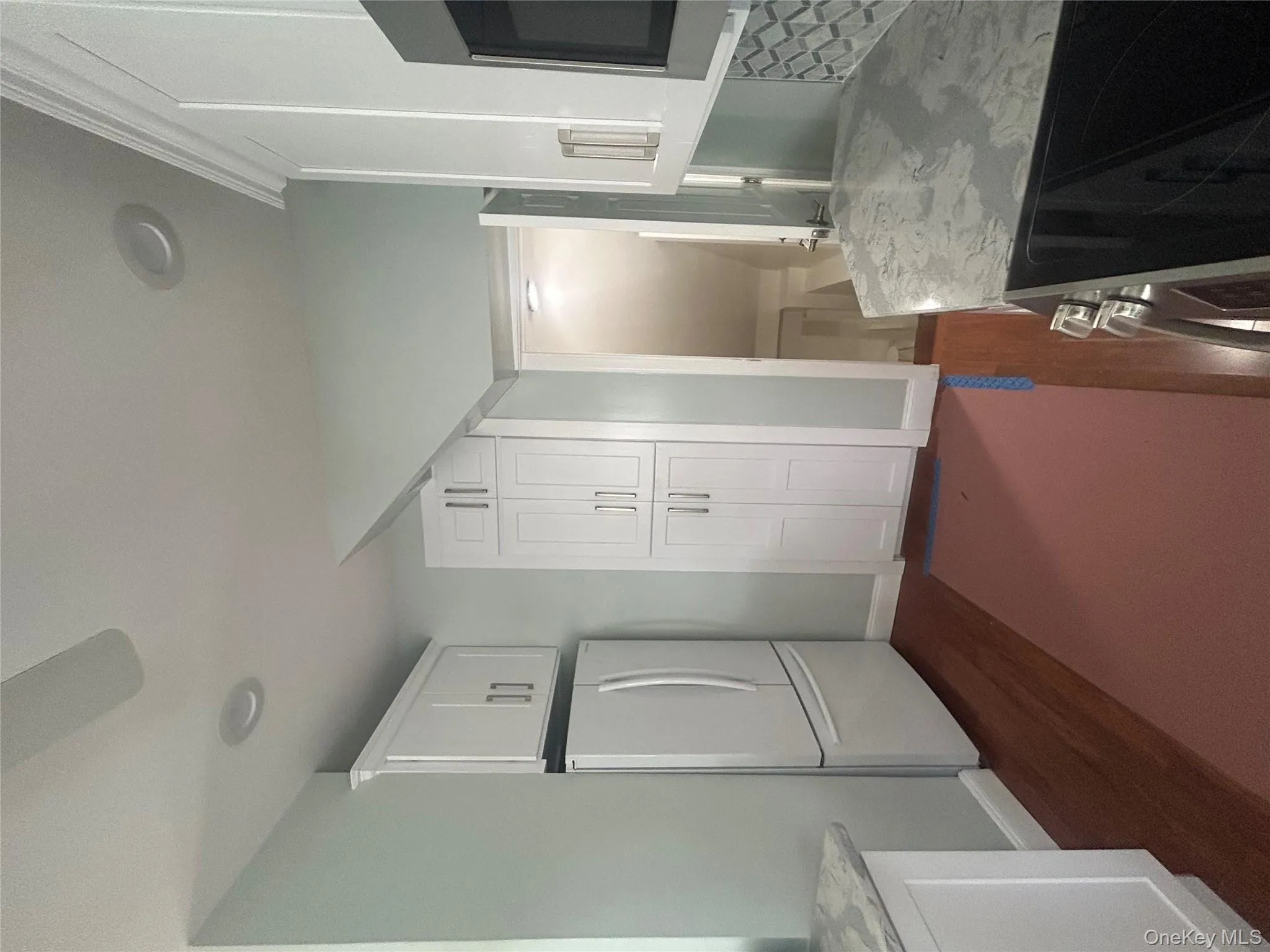 Kitchen with white range oven, white cabinetry, fridge, dark wood-type flooring, and stainless steel microwave Kitchen with white range oven, white cabinetry, fridge, dark wood-type flooring, and stainless steel microwave