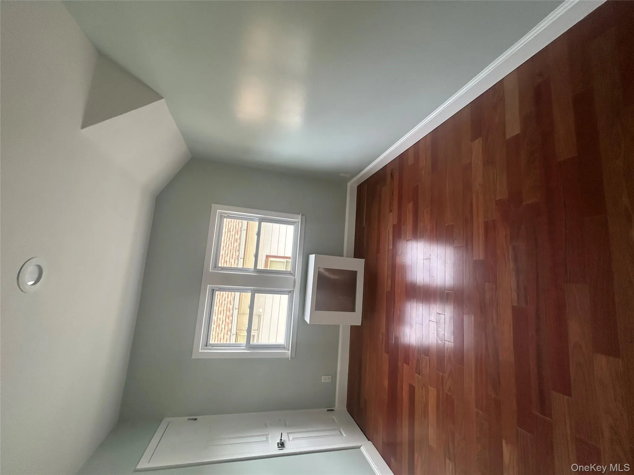 Bonus room with dark wood-style flooring, lofted ceiling, and radiator heating unit Bonus room with dark wood-style flooring, lofted ceiling, and radiator heating unit