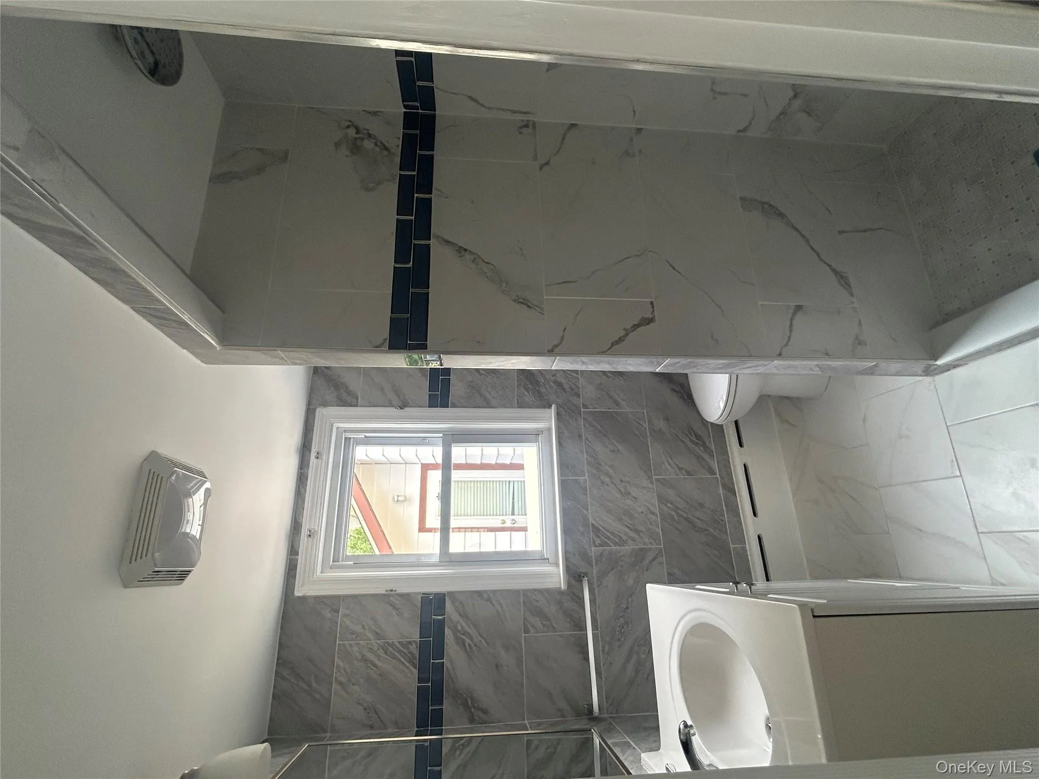 Bathroom with tile walls, vanity, a shower stall, and light marble finish floors Bathroom with tile walls, vanity, a shower stall, and light marble finish floors