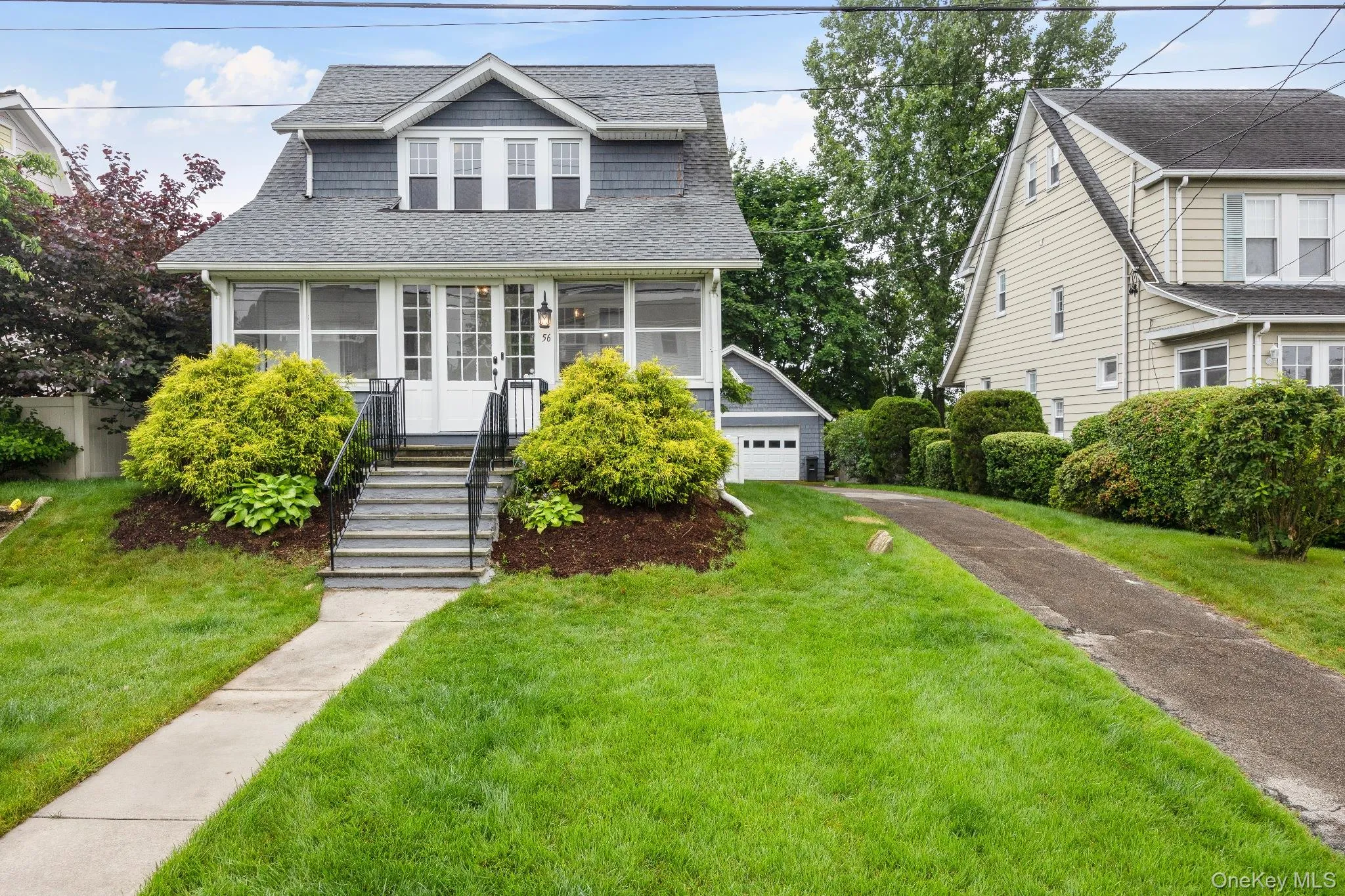 Bungalow-style home featuring roof with shingles, a front lawn, an outbuilding, and a sunroom Bungalow-style home featuring roof with shingles, a front lawn, an outbuilding, and a sunroom