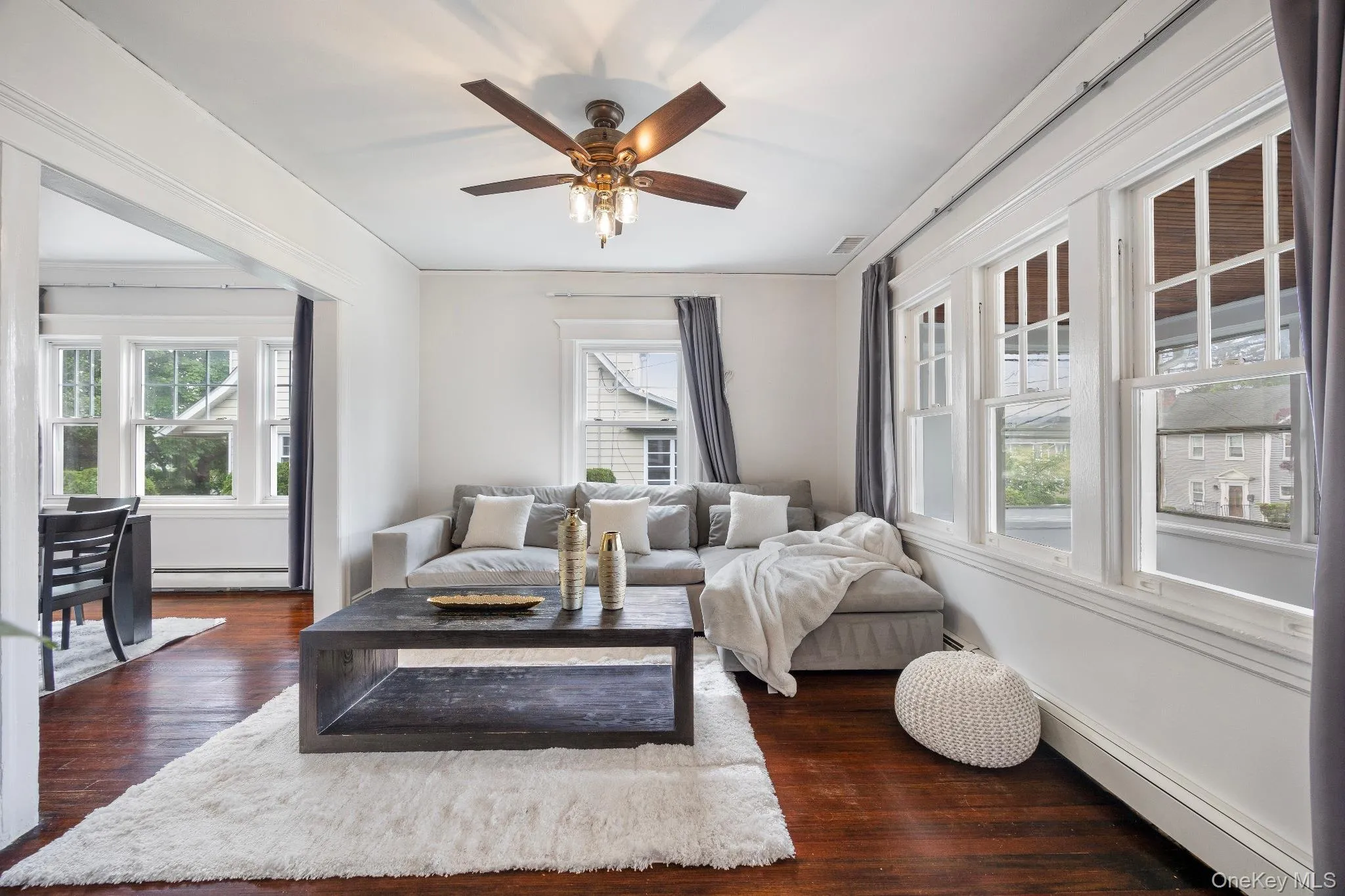 Living room with dark wood finished floors, plenty of natural light, and ceiling fan Living room with dark wood finished floors, plenty of natural light, and ceiling fan