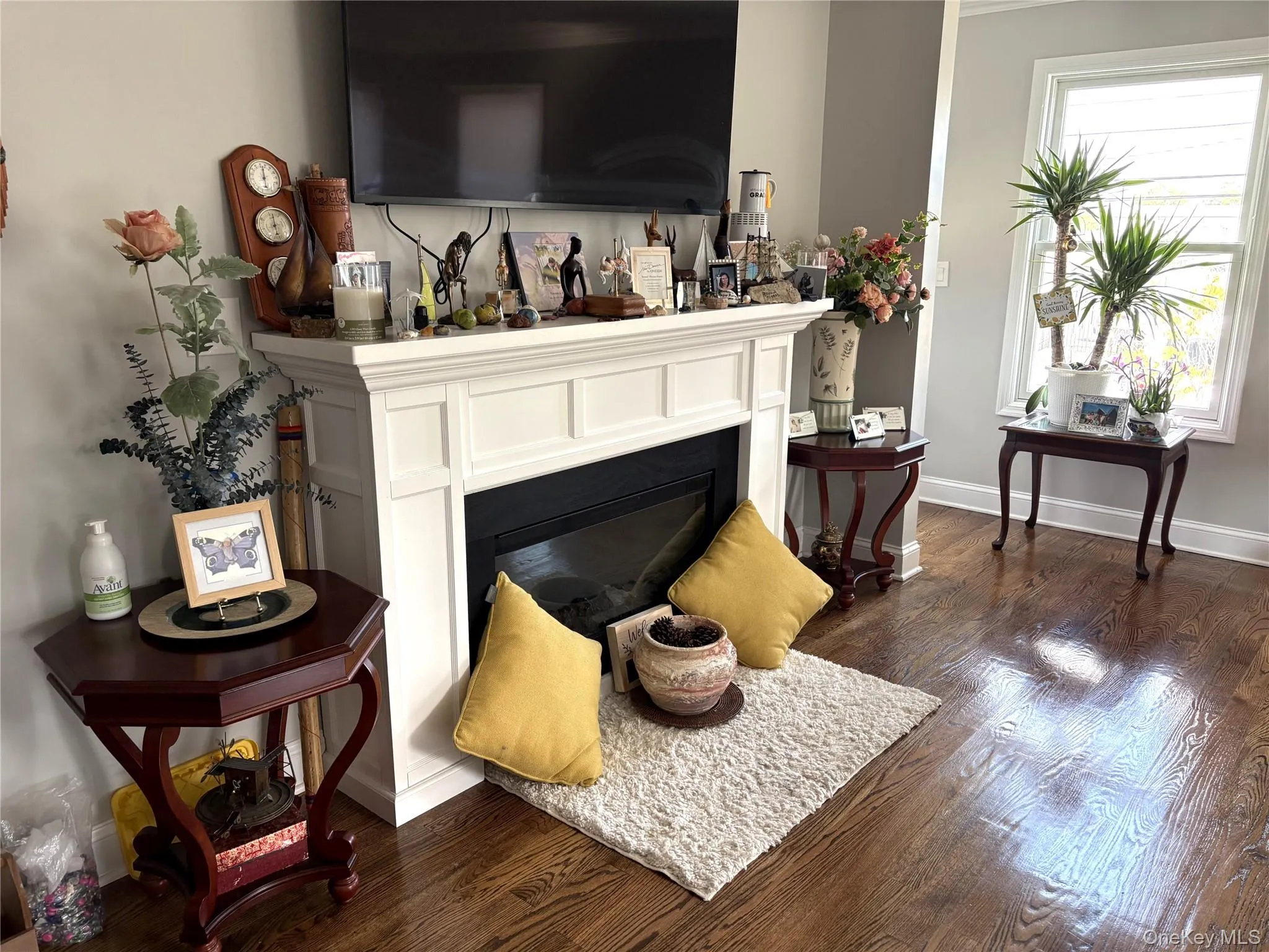 Living room featuring an electric  fireplace and dark hardwood flooring Living room featuring an electric  fireplace and dark hardwood flooring