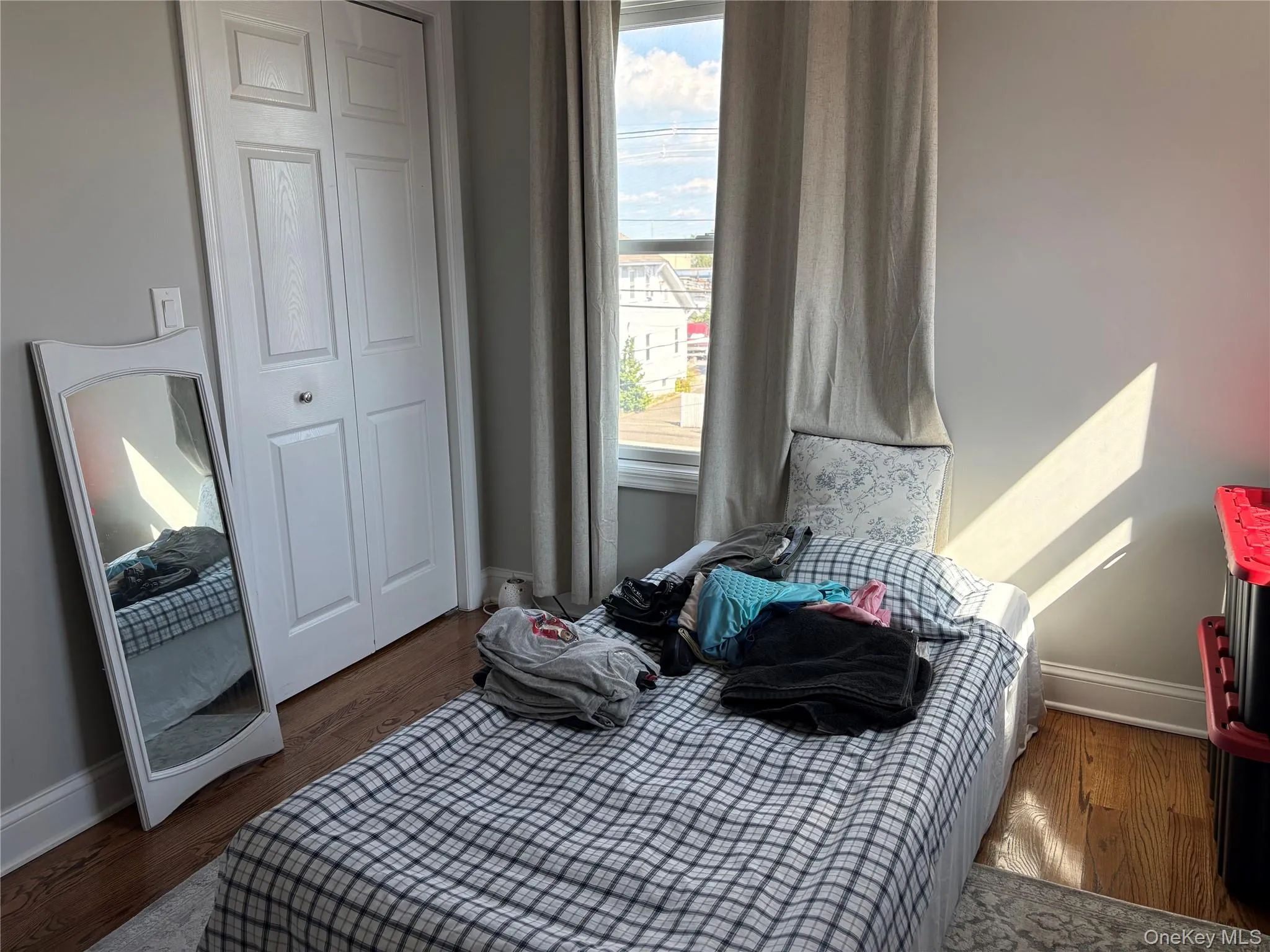 Bedroom featuring dark hardwood floors and a closet Bedroom featuring dark hardwood floors and a closet