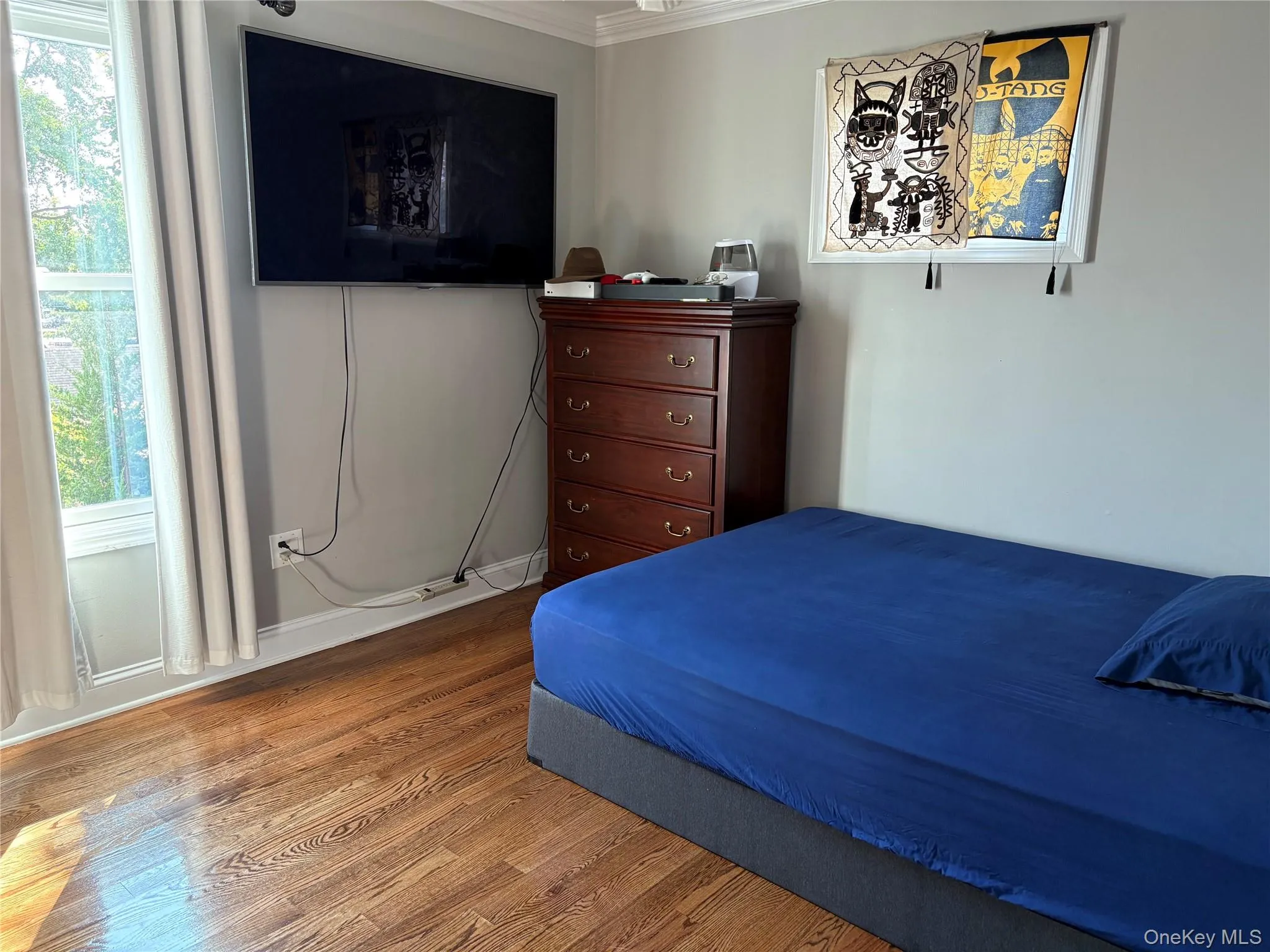 Bedroom featuring hardwood floors and ornamental molding Bedroom featuring hardwood floors and ornamental molding