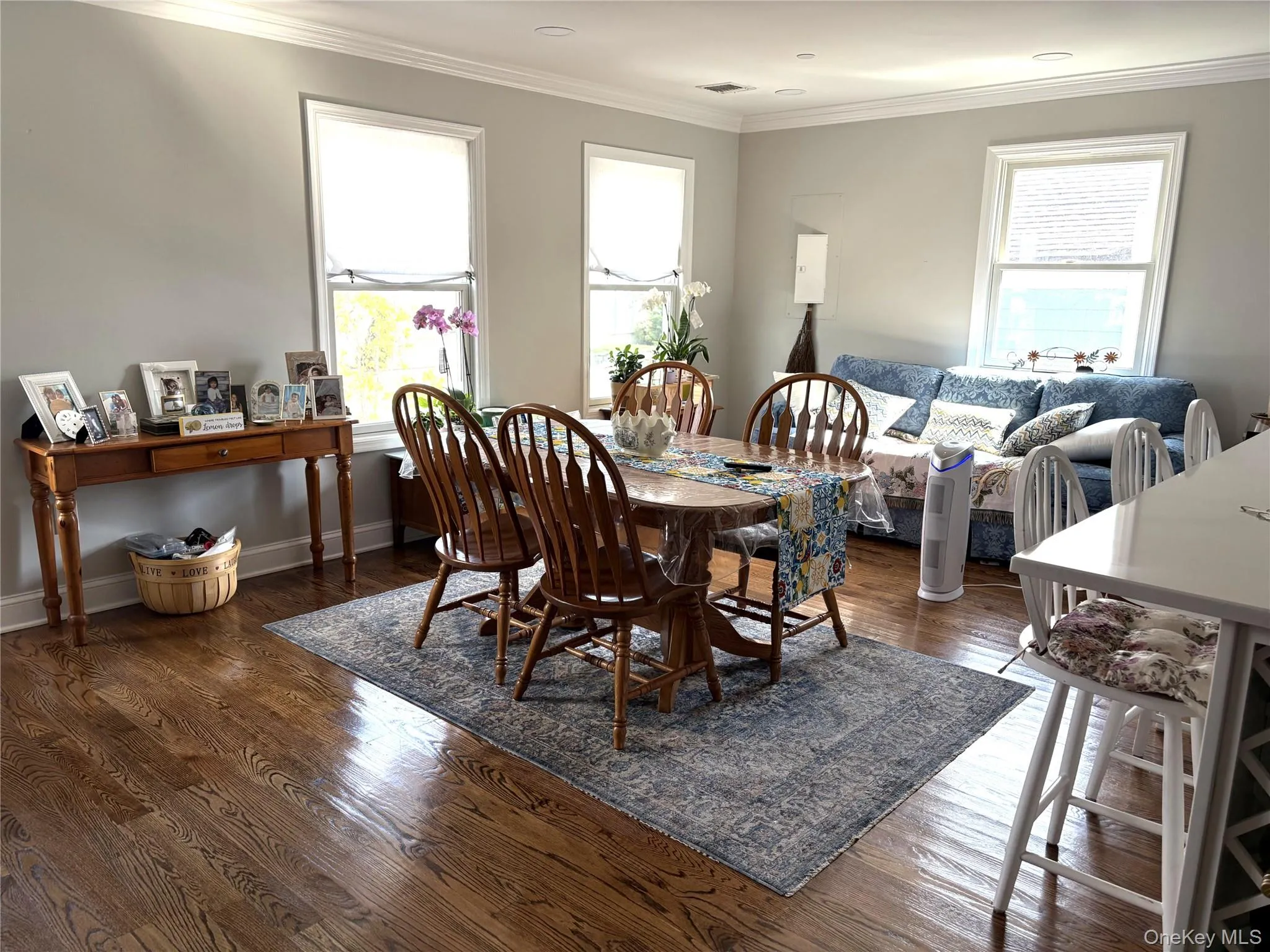 Open floor plan featuring plenty of natural light, crown molding, and dark hardwood flooring Open floor plan featuring plenty of natural light, crown molding, and dark hardwood flooring