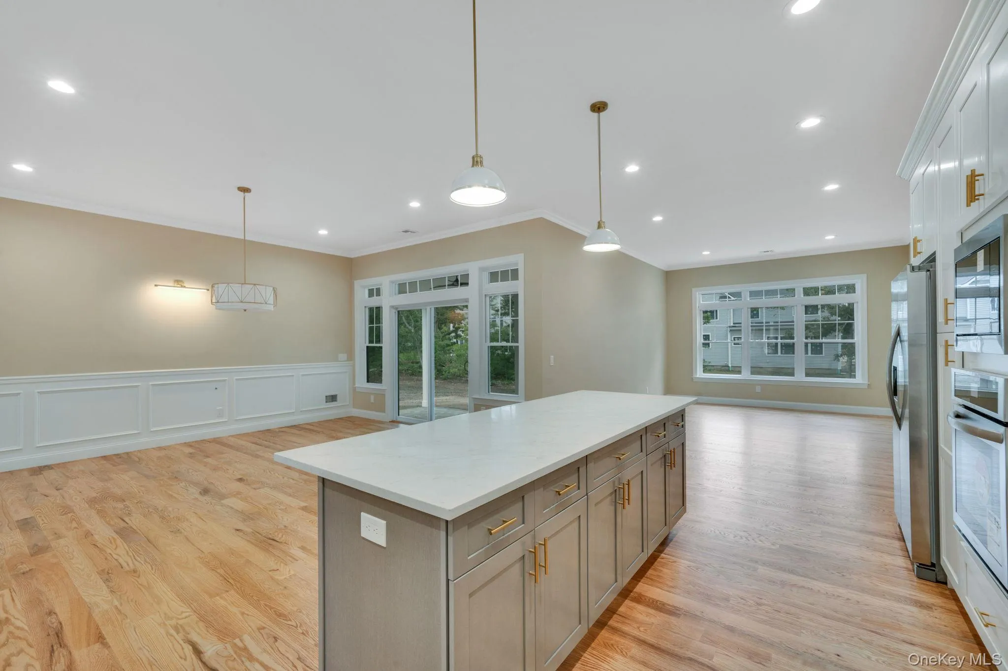 Kitchen with a decorative wall, decorative light fixtures, open floor plan, crown molding, and wainscoting Kitchen with a decorative wall, decorative light fixtures, open floor plan, crown molding, and wainscoting