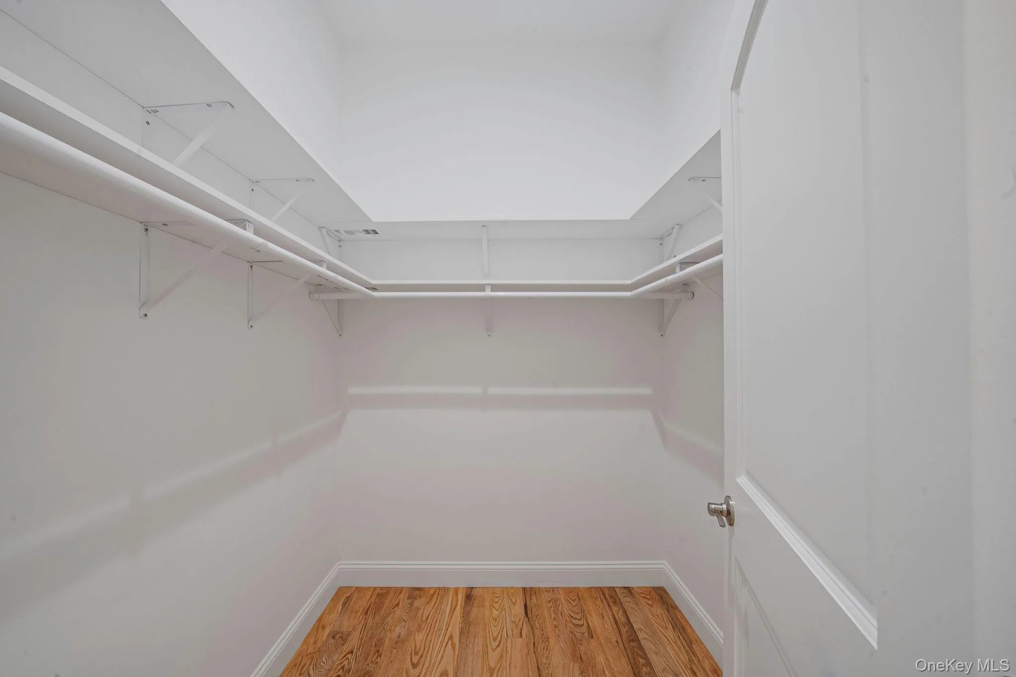 Walk in closet featuring light wood-type flooring Walk in closet featuring light wood-type flooring