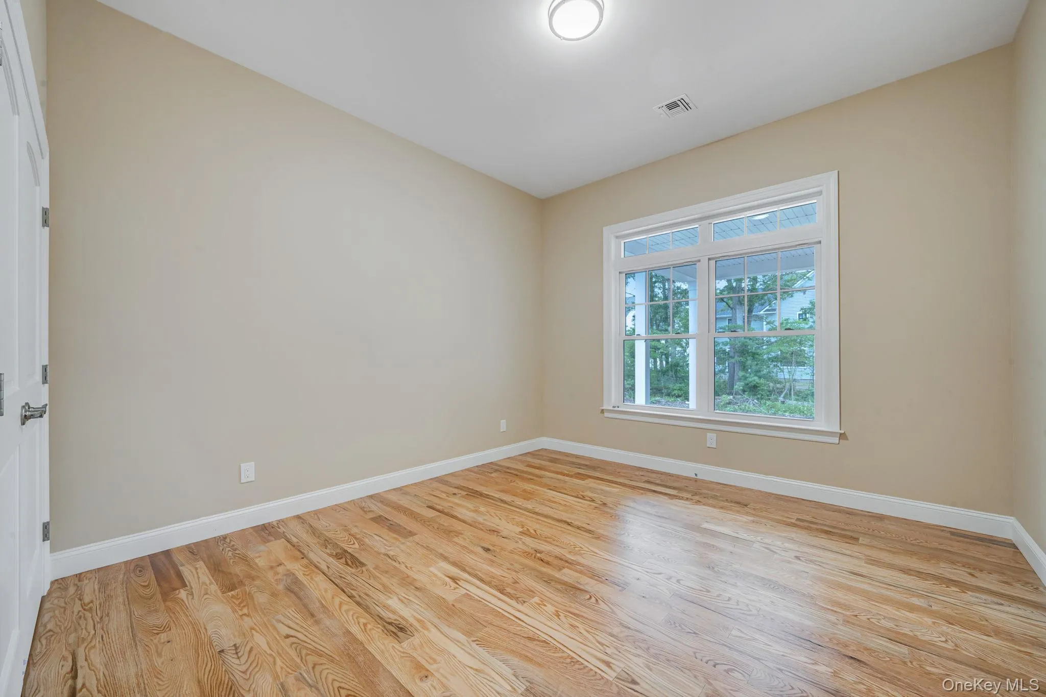 Unfurnished room with light wood-style floors and baseboards Unfurnished room with light wood-style floors and baseboards