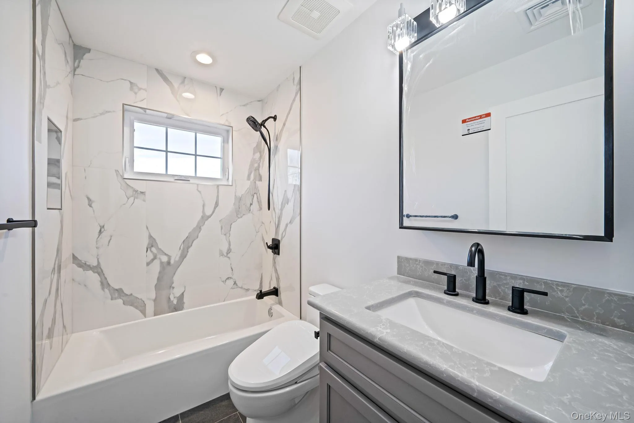 Bathroom featuring a combined bath / shower with marble appearance, vanity, and recessed lighting Bathroom featuring a combined bath / shower with marble appearance, vanity, and recessed lighting