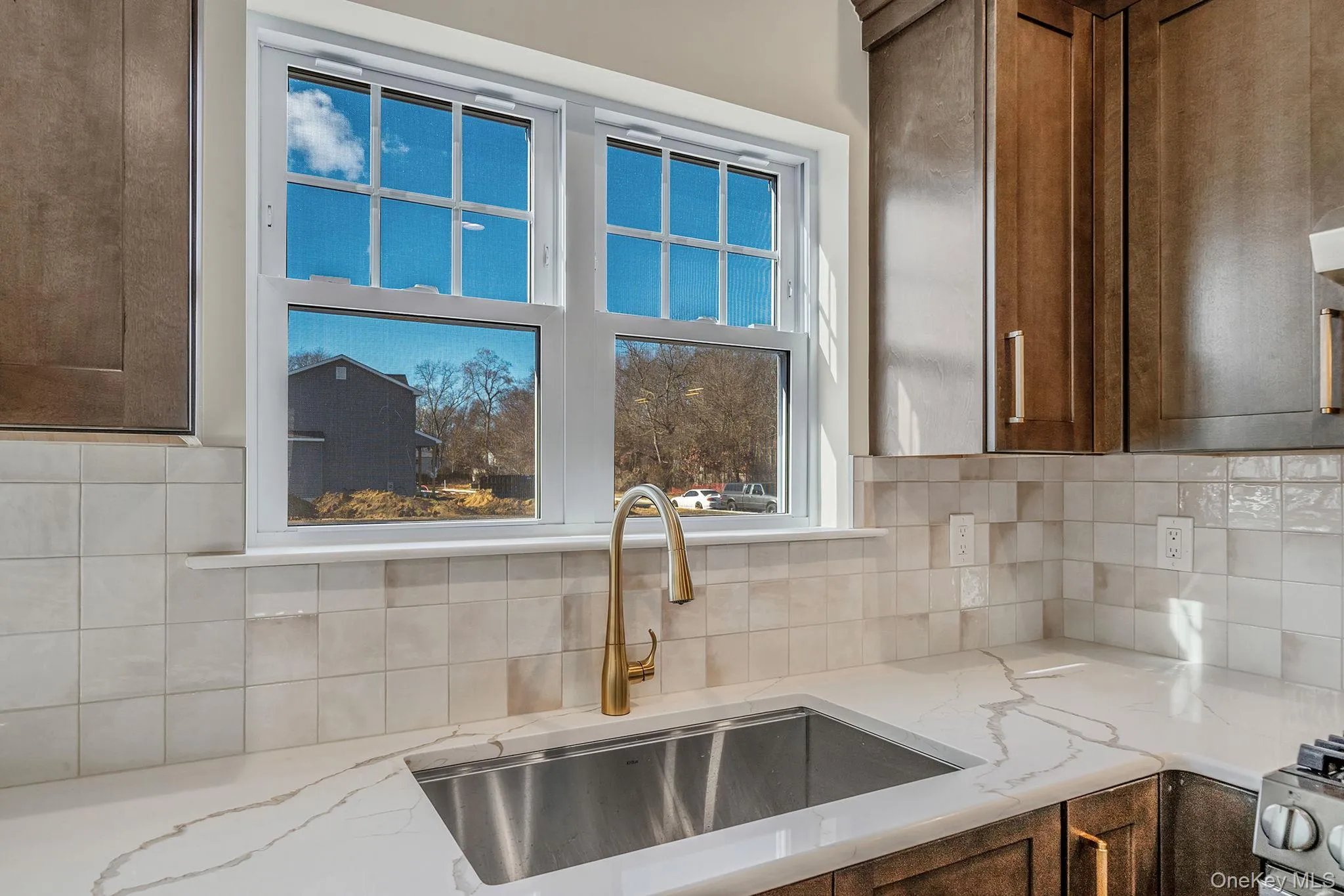Kitchen with light stone counters and decorative backsplash Kitchen with light stone counters and decorative backsplash