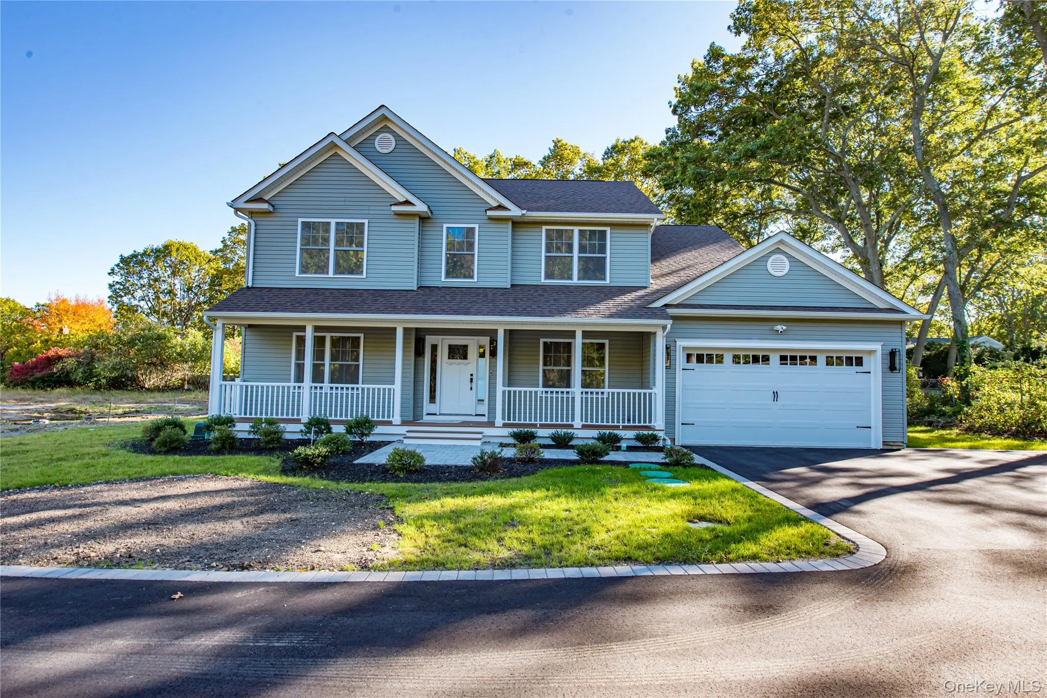 View of front facade featuring covered porch, asphalt driveway, a shingled roof, a front yard, and a garage View of front facade featuring covered porch, asphalt driveway, a shingled roof, a front yard, and a garage