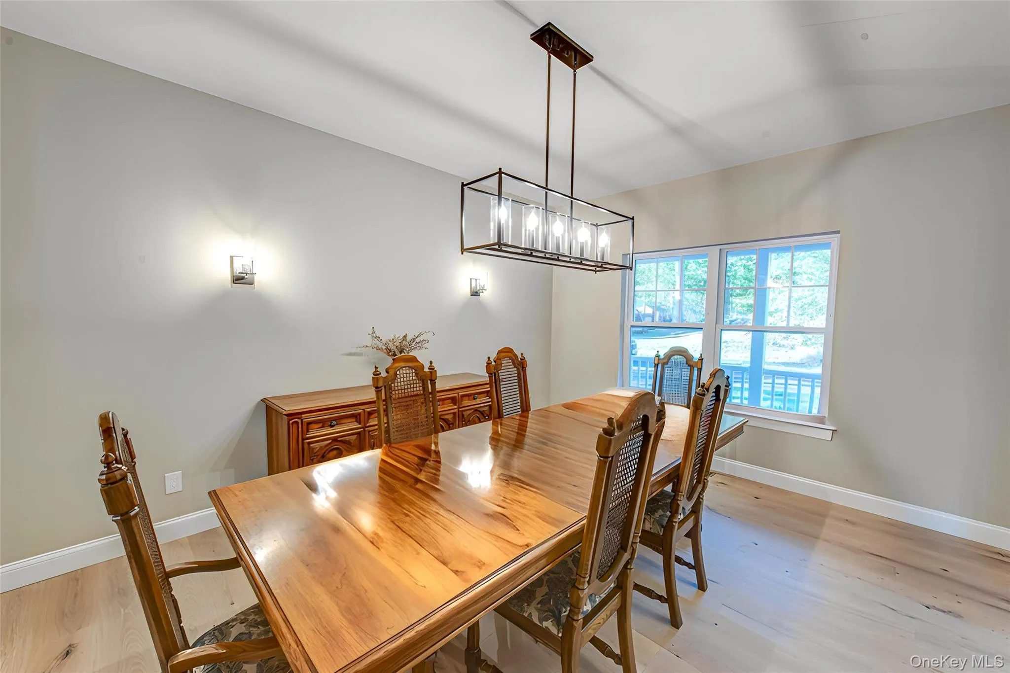 Dining room with light wood-style flooring and a chandelier Dining room with light wood-style flooring and a chandelier