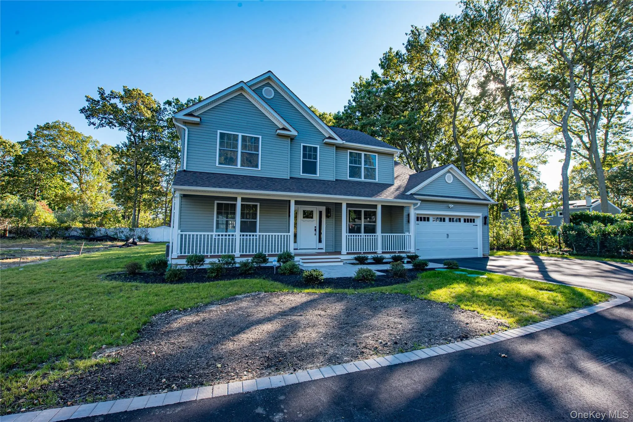 View of front facade featuring a porch, driveway, a shingled roof, and an attached garage View of front facade featuring a porch, driveway, a shingled roof, and an attached garage