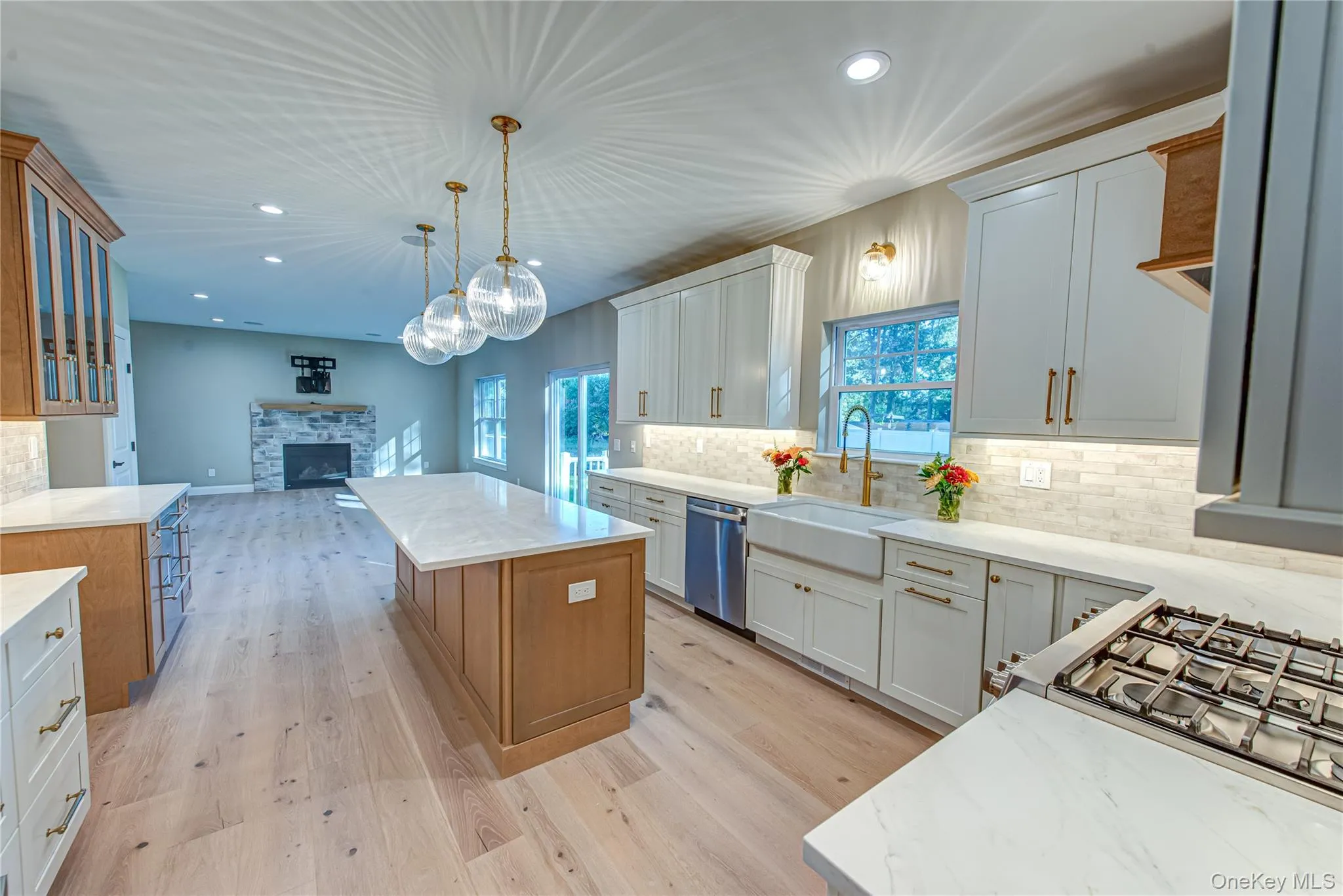 Kitchen featuring recessed lighting, decorative backsplash, a fireplace, a center island, and open floor plan Kitchen featuring recessed lighting, decorative backsplash, a fireplace, a center island, and open floor plan