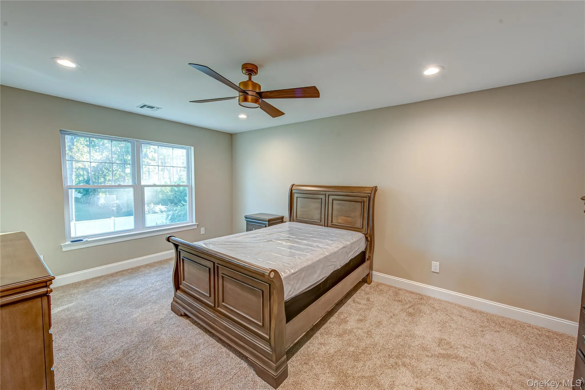 Bedroom featuring light carpet, ceiling fan, and recessed lighting Bedroom featuring light carpet, ceiling fan, and recessed lighting