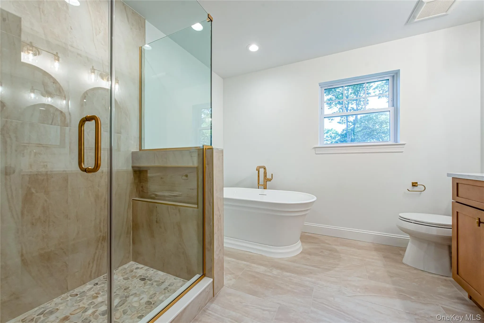 Bathroom with a stall shower, a soaking tub, vanity, and recessed lighting Bathroom with a stall shower, a soaking tub, vanity, and recessed lighting
