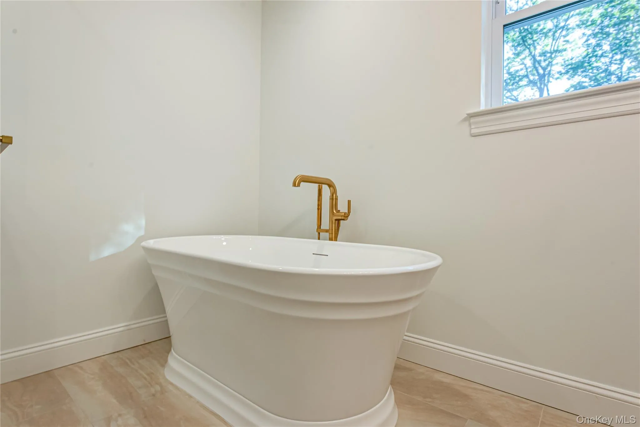 Full bath with baseboards and a freestanding bath Full bath with baseboards and a freestanding bath