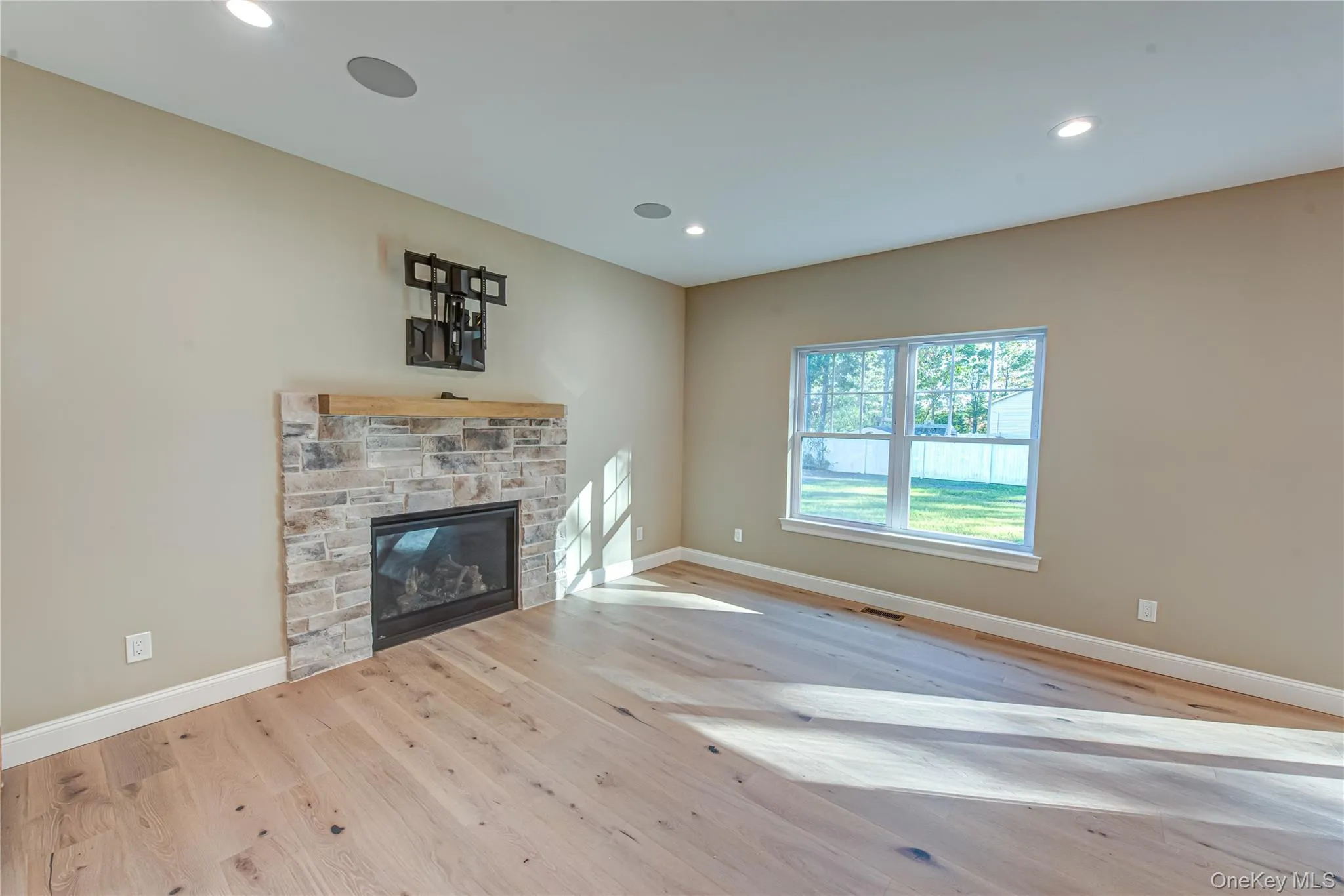 Unfurnished living room featuring a fireplace, light wood-style flooring, and recessed lighting Unfurnished living room featuring a fireplace, light wood-style flooring, and recessed lighting
