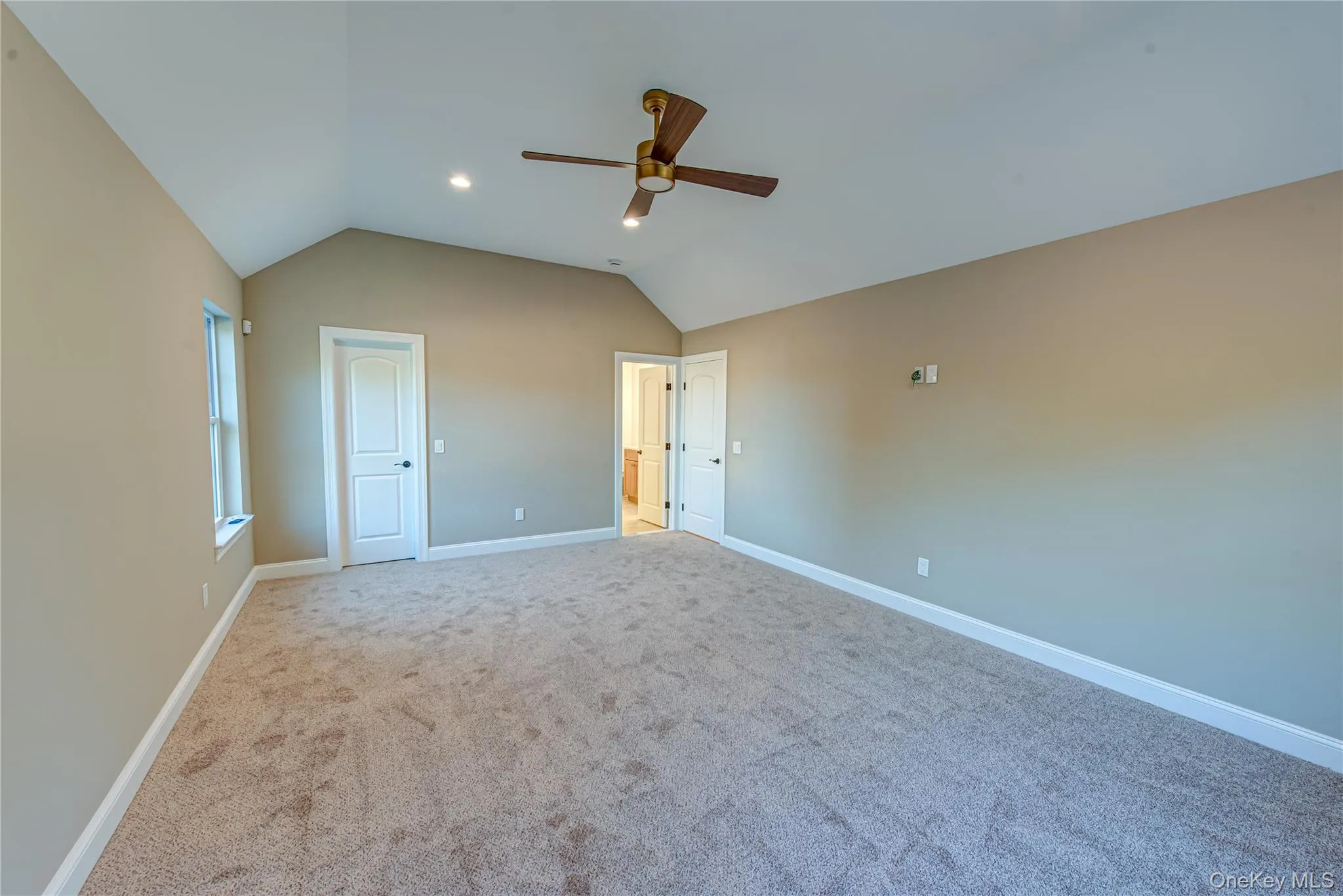 Unfurnished bedroom with vaulted ceiling, a ceiling fan, carpet floors, and recessed lighting Unfurnished bedroom with vaulted ceiling, a ceiling fan, carpet floors, and recessed lighting