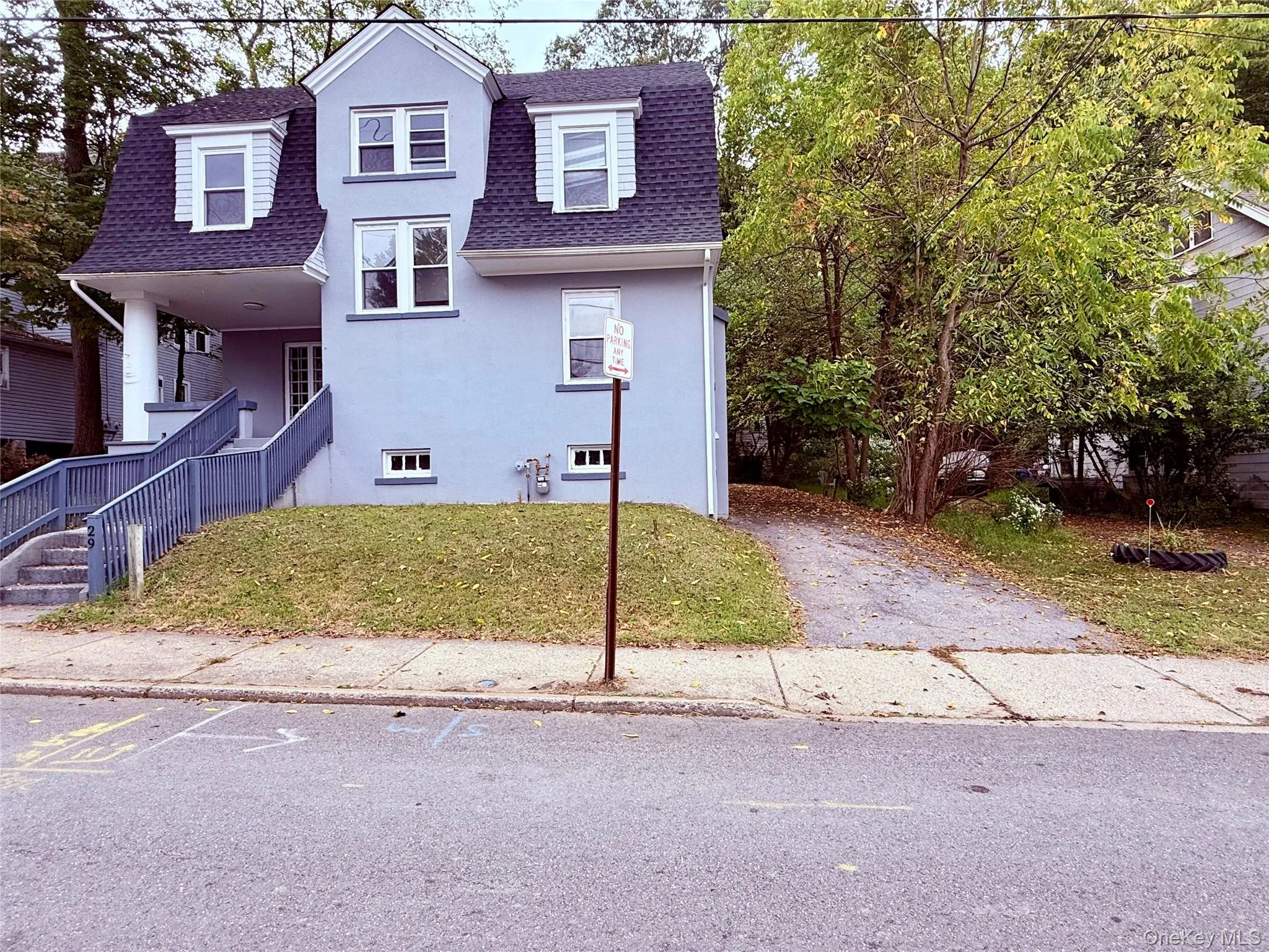 View of front facade featuring a shingled roof, a porch, stucco siding, and a front lawn View of front facade featuring a shingled roof, a porch, stucco siding, and a front lawn