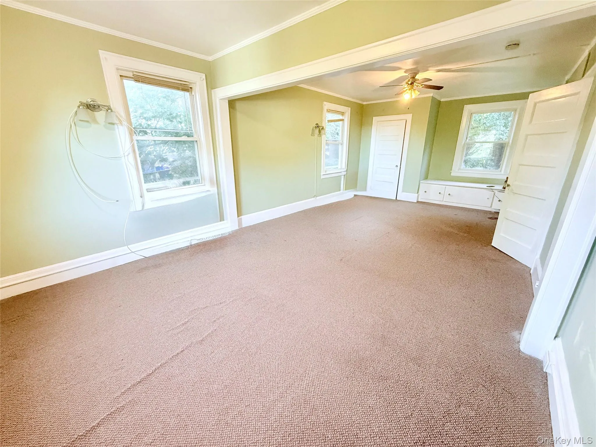 Unfurnished bedroom featuring crown molding, carpet flooring, and ceiling fan Unfurnished bedroom featuring crown molding, carpet flooring, and ceiling fan