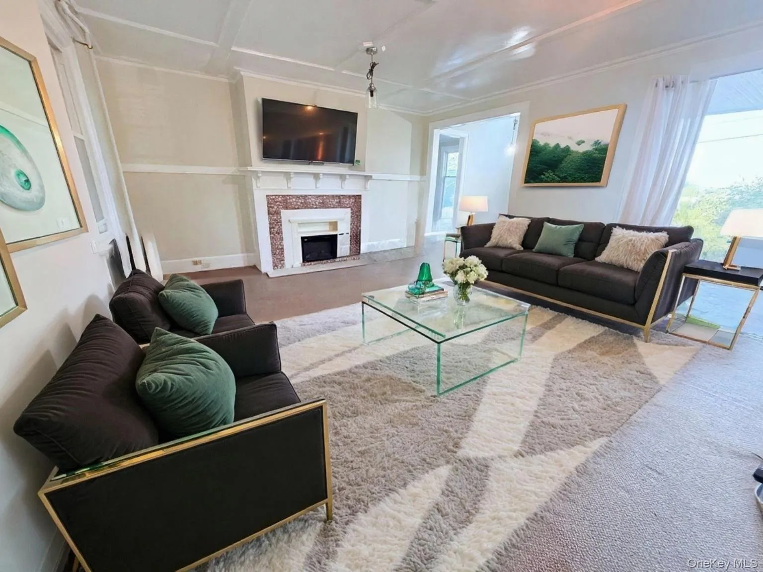 Living area with carpet flooring, a fireplace, and plenty of natural light Living area with carpet flooring, a fireplace, and plenty of natural light