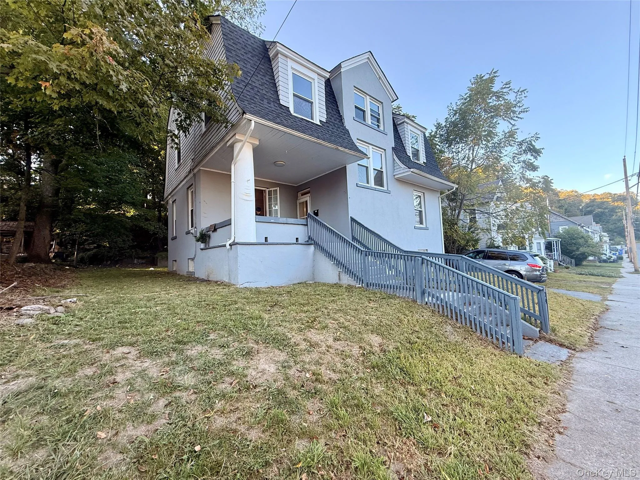 View of front of home featuring a shingled roof, a porch, a front yard, and a chimney View of front of home featuring a shingled roof, a porch, a front yard, and a chimney