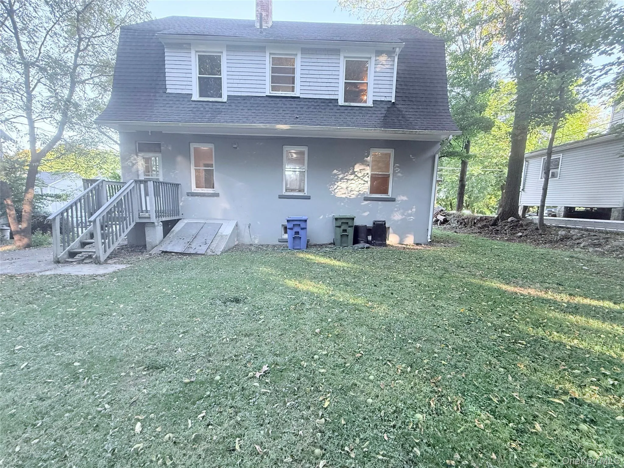 Rear view of property with a shingled roof and a lawn Rear view of property with a shingled roof and a lawn