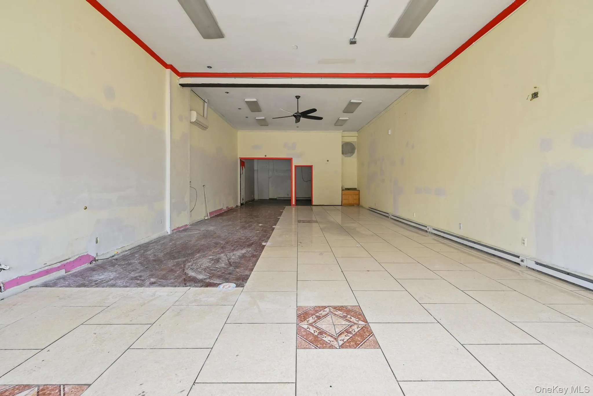 Unfurnished room featuring ornamental molding, light tile patterned floors, ceiling fan, and baseboard heating Unfurnished room featuring ornamental molding, light tile patterned floors, ceiling fan, and baseboard heating