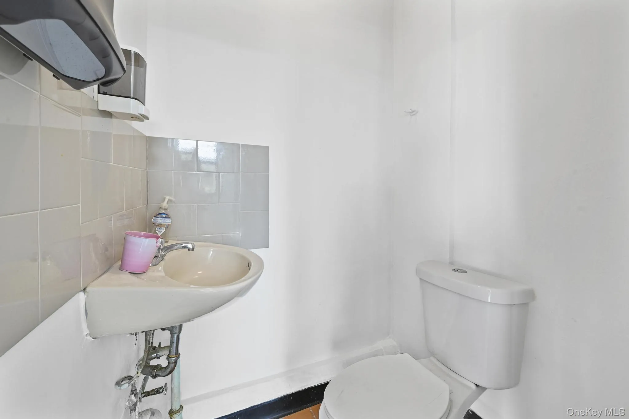 Half bath with tasteful backsplash and toilet Half bath with tasteful backsplash and toilet