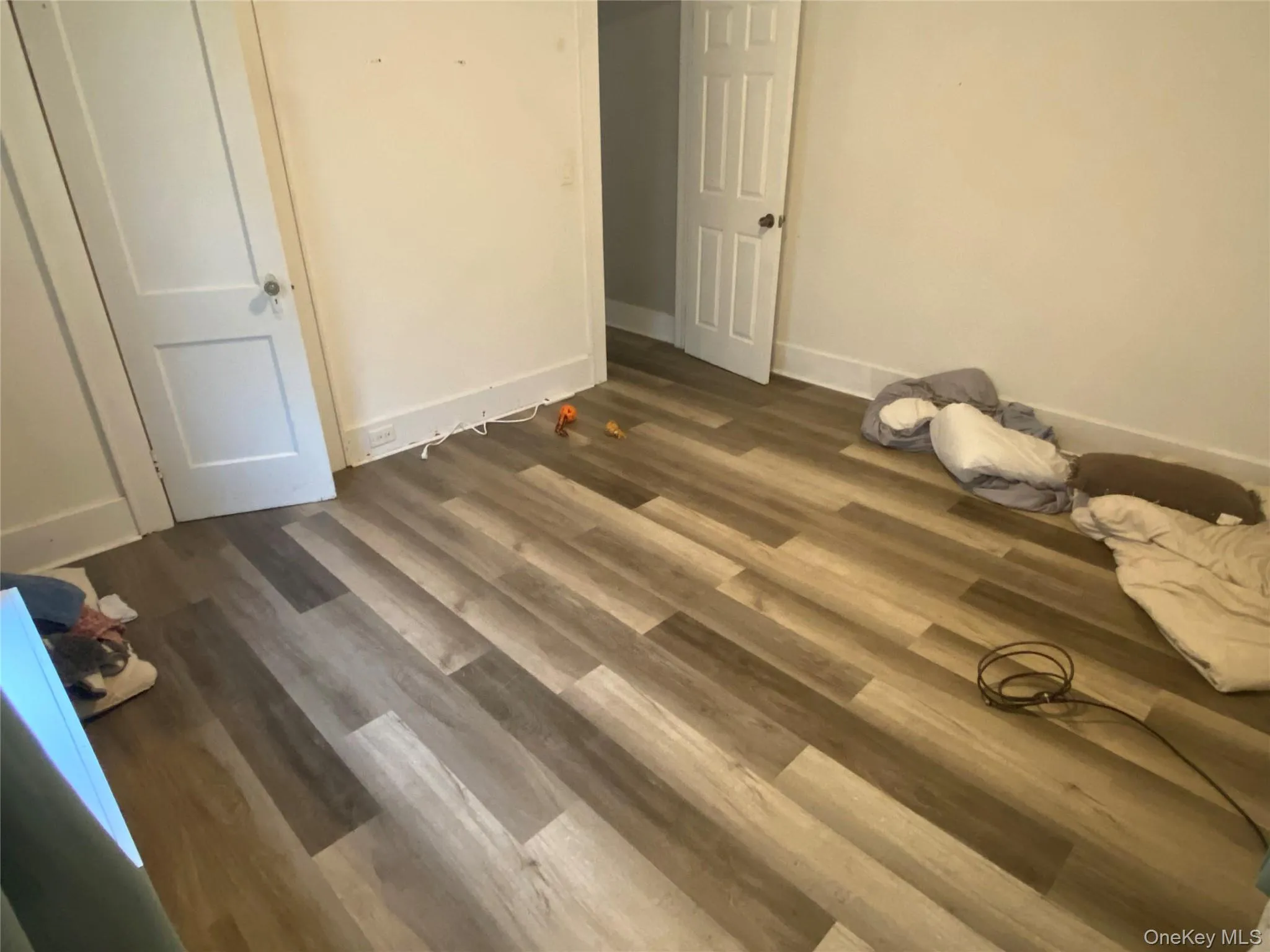 Unfurnished bedroom with baseboards and dark wood-style floors Unfurnished bedroom with baseboards and dark wood-style floors