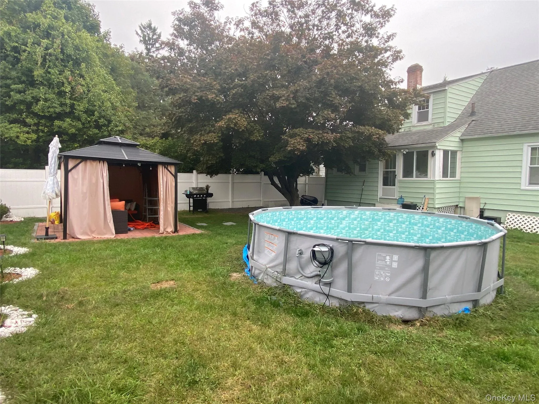 Fenced backyard with a patio area and a gazebo Fenced backyard with a patio area and a gazebo
