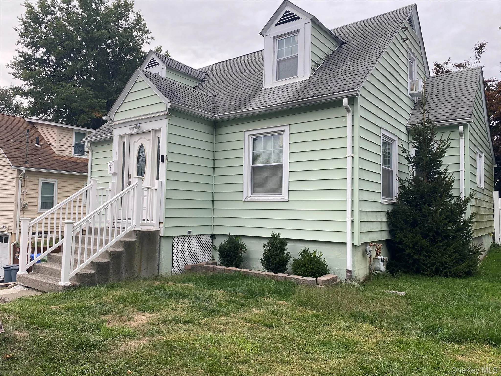 View of front facade with a shingled roof and a front yard View of front facade with a shingled roof and a front yard