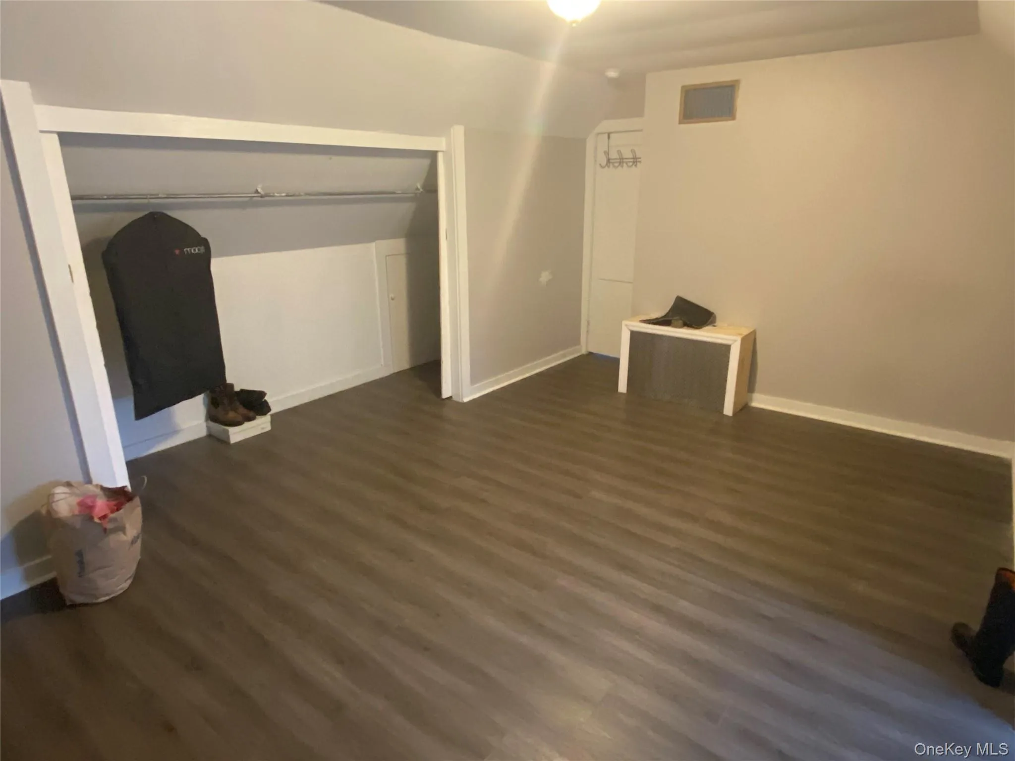 Unfurnished bedroom with dark wood-style floors and vaulted ceiling Unfurnished bedroom with dark wood-style floors and vaulted ceiling