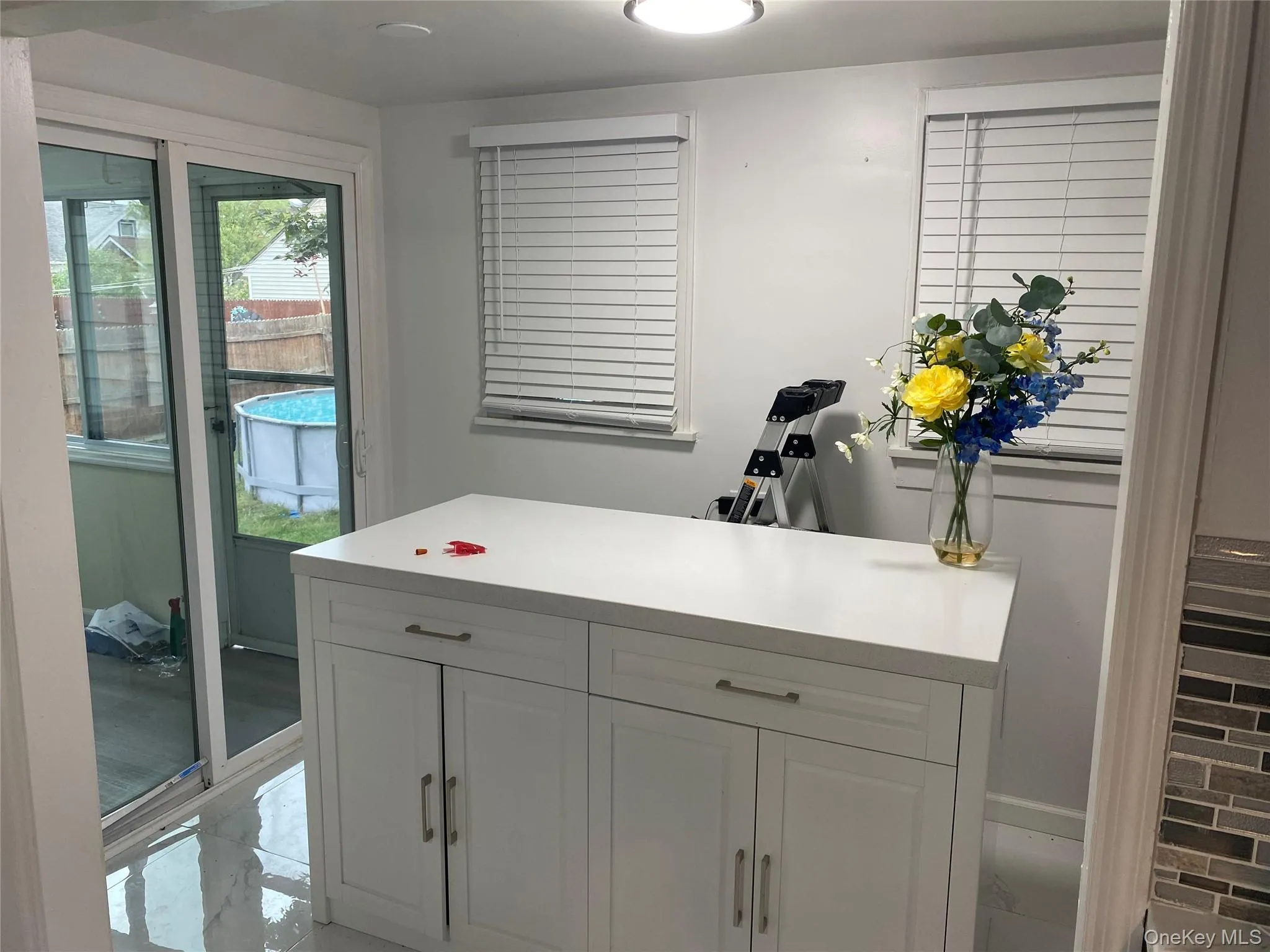 Bar with light countertops and white cabinetry Bar with light countertops and white cabinetry