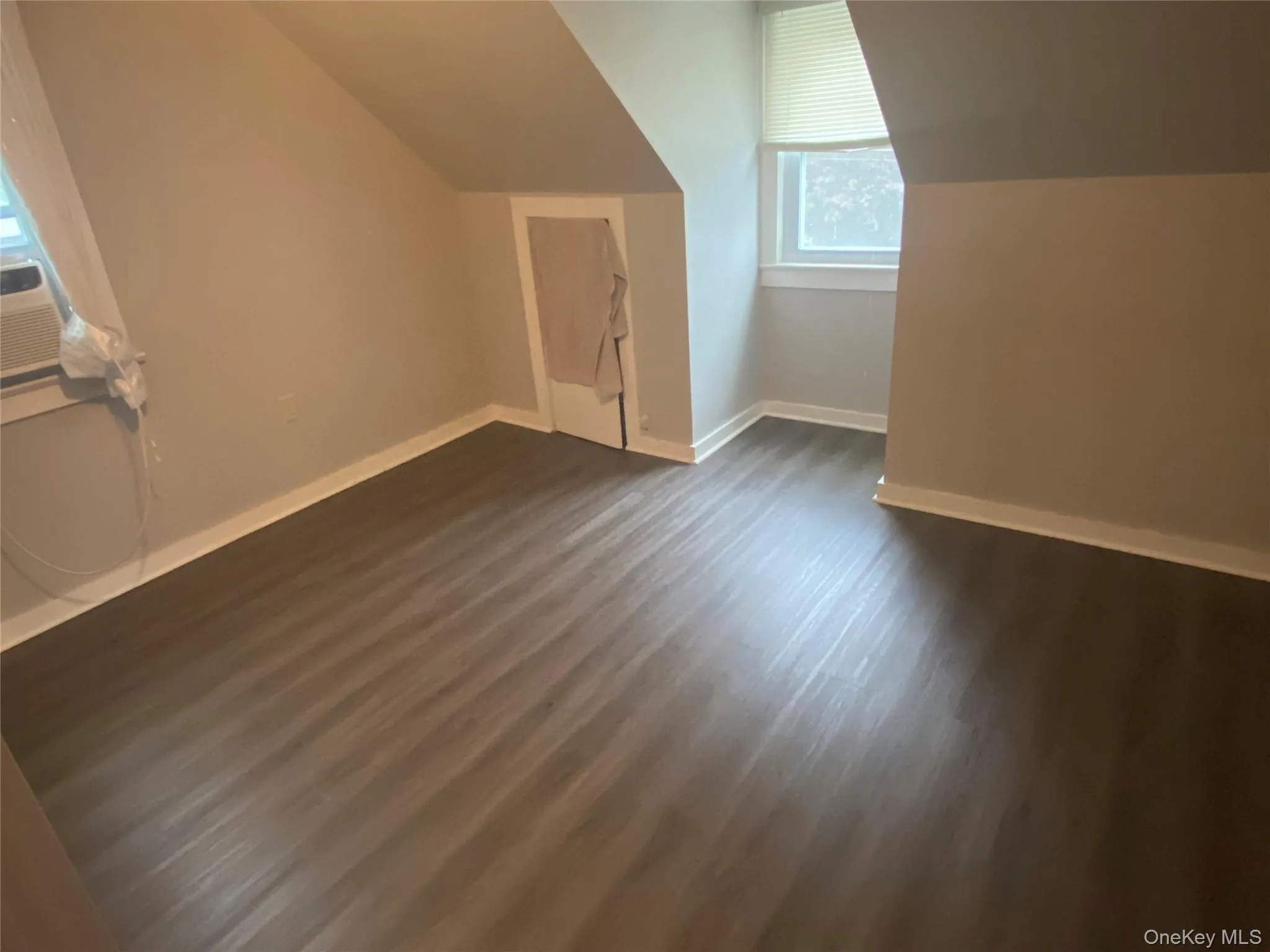 Bonus room featuring dark wood finished floors and vaulted ceiling Bonus room featuring dark wood finished floors and vaulted ceiling