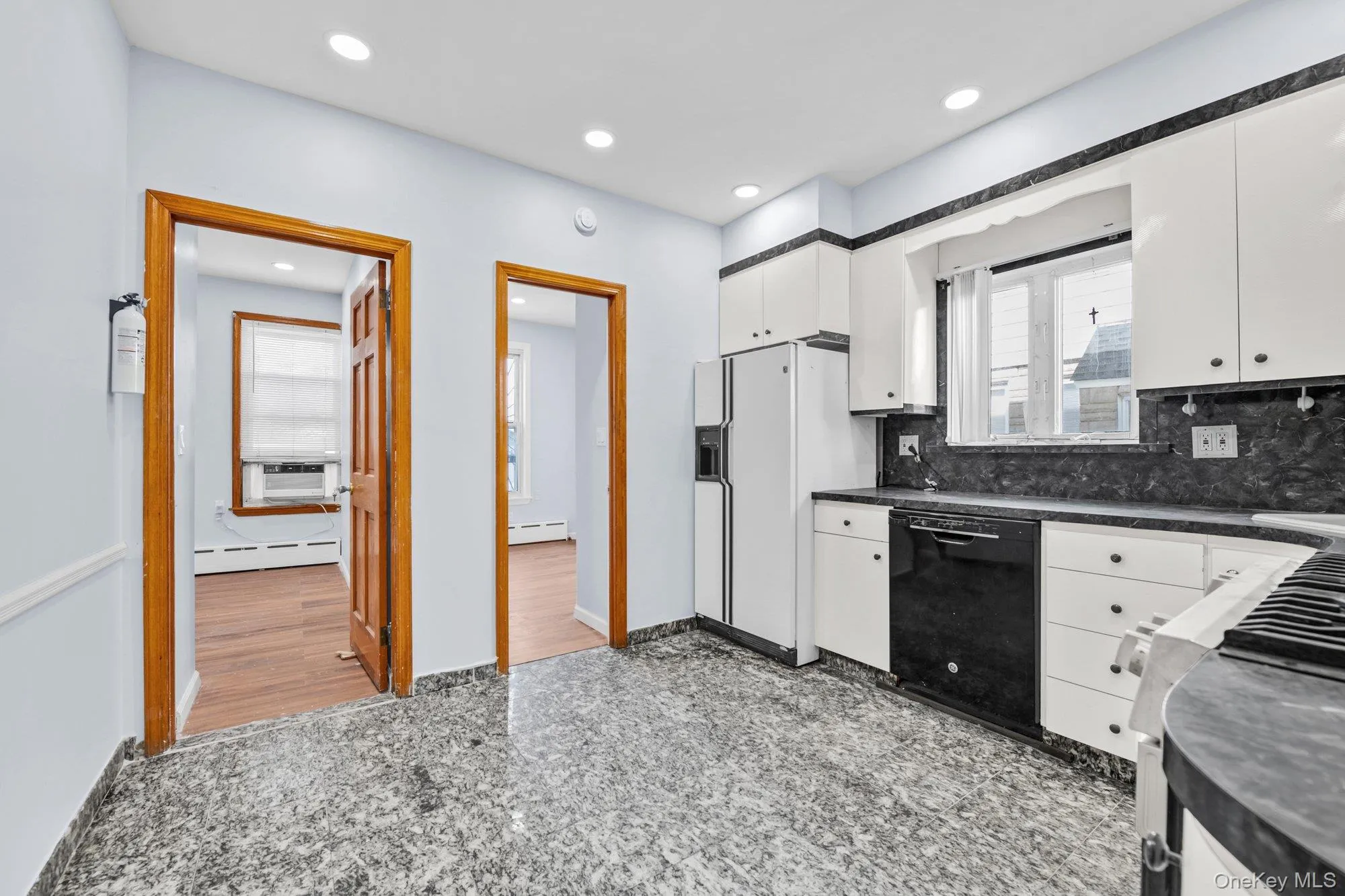 Kitchen featuring granite tiled floors, white cabinetry, dark countertops, black dishwasher, and stainless steel gas range Kitchen featuring granite tiled floors, white cabinetry, dark countertops, black dishwasher, and stainless steel gas range