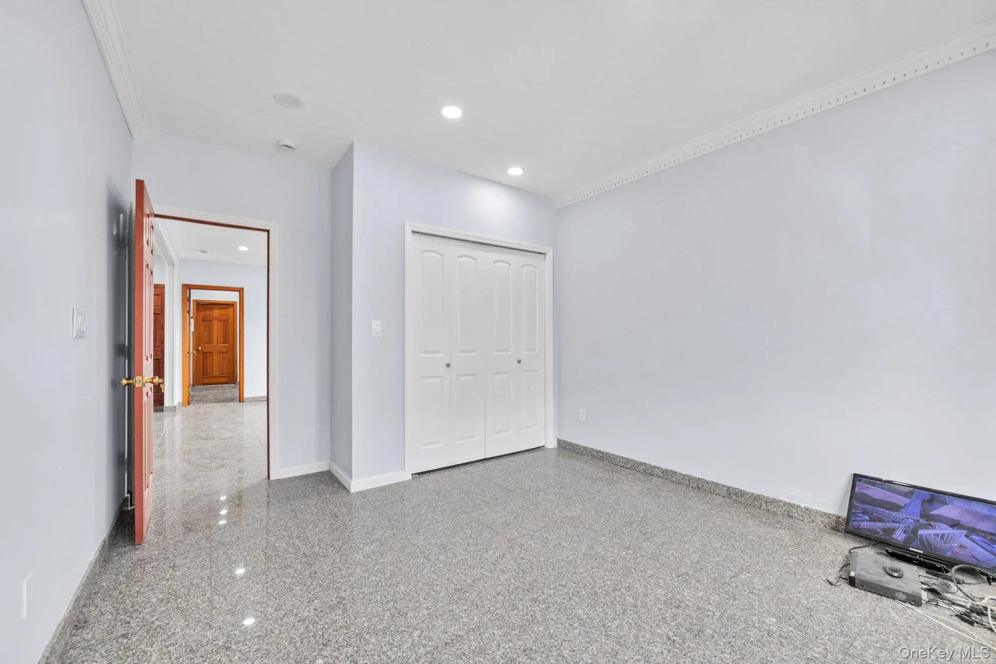 Unfurnished bedroom with ornamental molding, recessed lighting, and a closet Unfurnished bedroom with ornamental molding, recessed lighting, and a closet