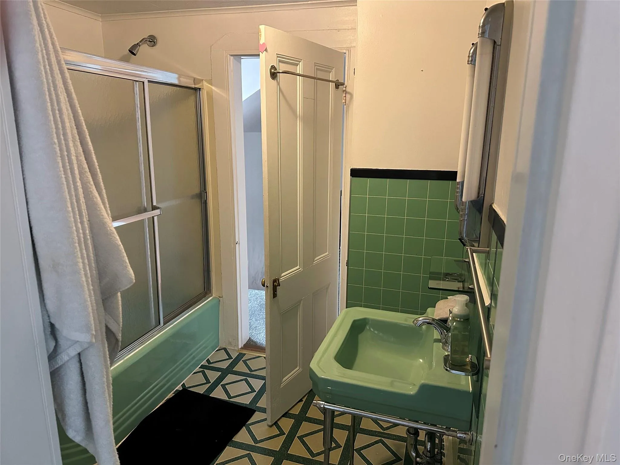 Full bathroom with enclosed tub / shower combo and tile walls Full bathroom with enclosed tub / shower combo and tile walls