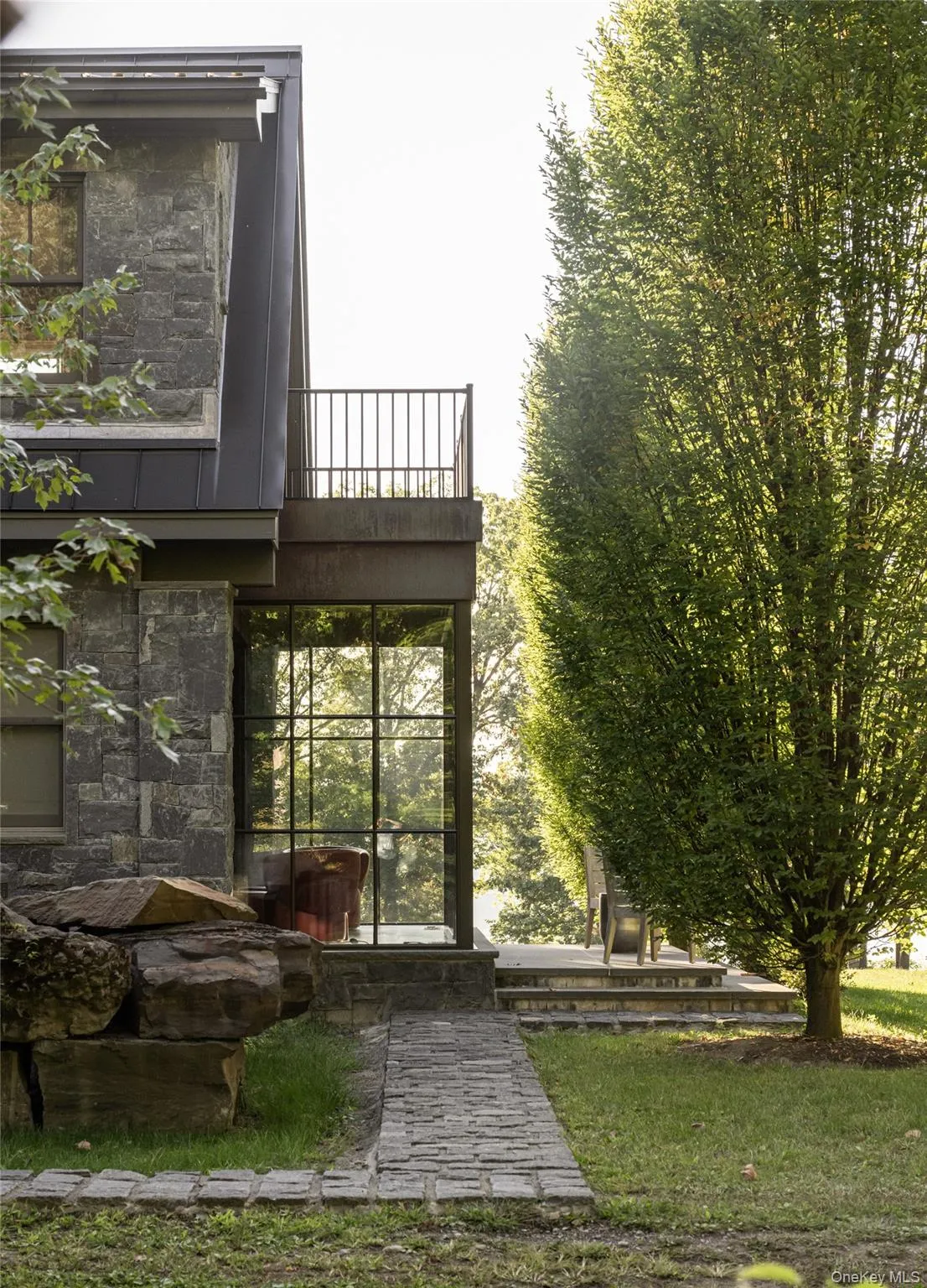 View of exterior entry featuring stone siding and a sunroom View of exterior entry featuring stone siding and a sunroom