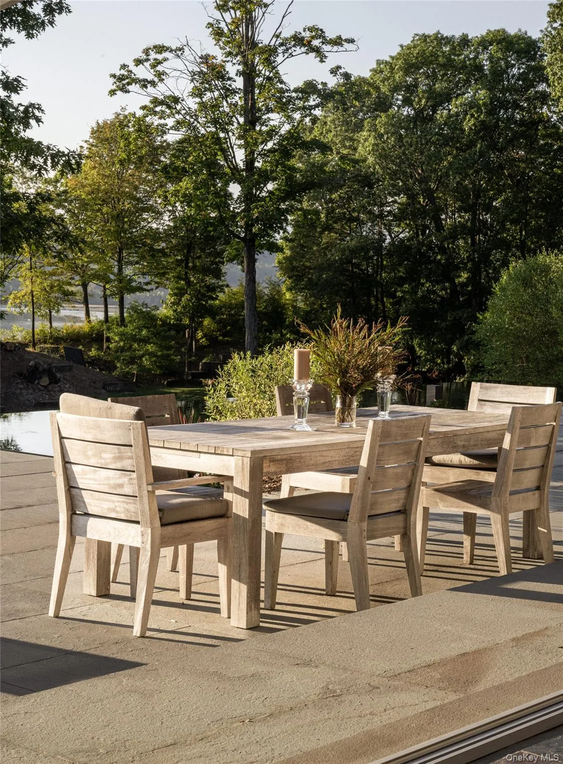 View of patio featuring outdoor dining space and view of scattered trees View of patio featuring outdoor dining space and view of scattered trees