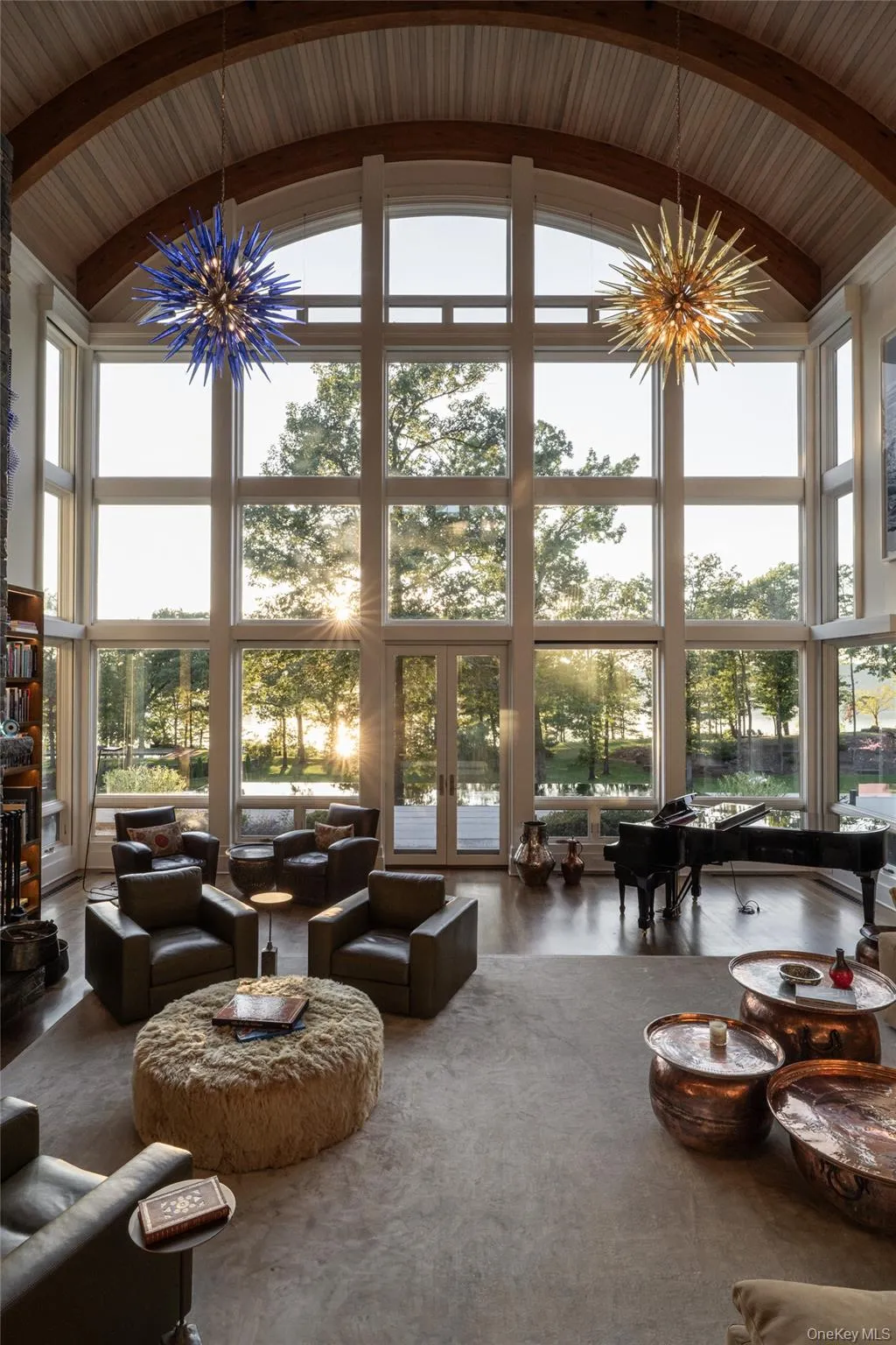 Living area featuring a chandelier, high vaulted ceiling, beamed ceiling, and expansive windows Living area featuring a chandelier, high vaulted ceiling, beamed ceiling, and expansive windows