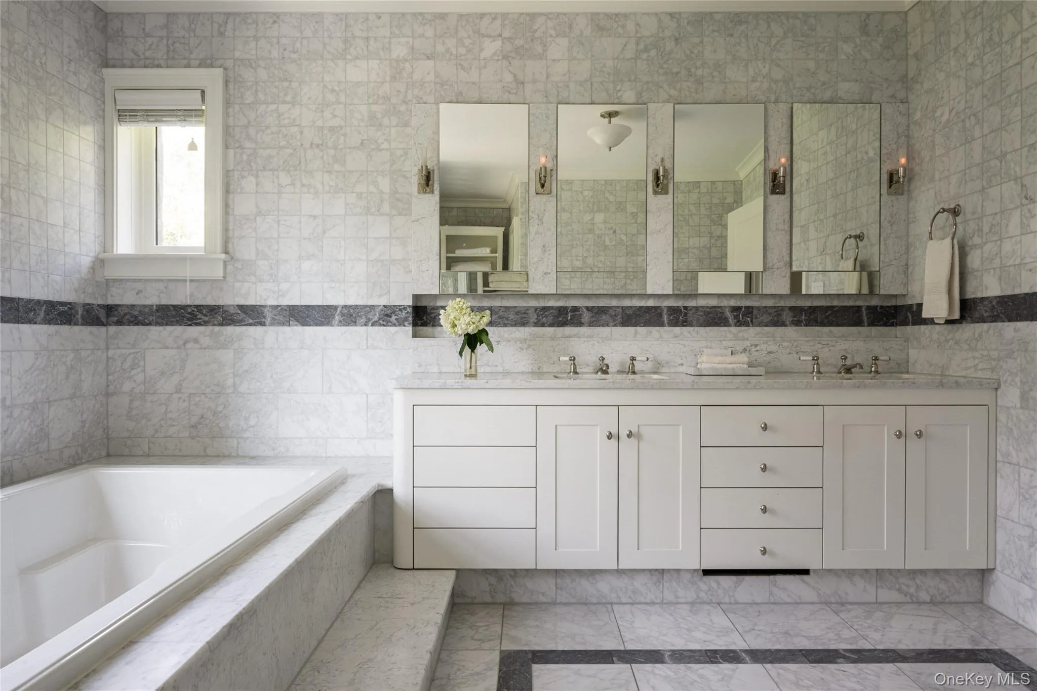 Bathroom with tile walls, a bath, double vanity, inlaid floor details, and a stall shower Bathroom with tile walls, a bath, double vanity, inlaid floor details, and a stall shower