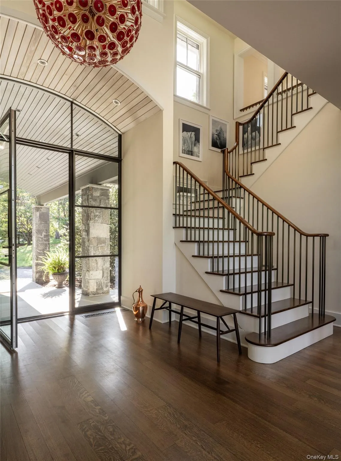 Stairway with wood-type flooring, a high ceiling, and a wall of windows Stairway with wood-type flooring, a high ceiling, and a wall of windows