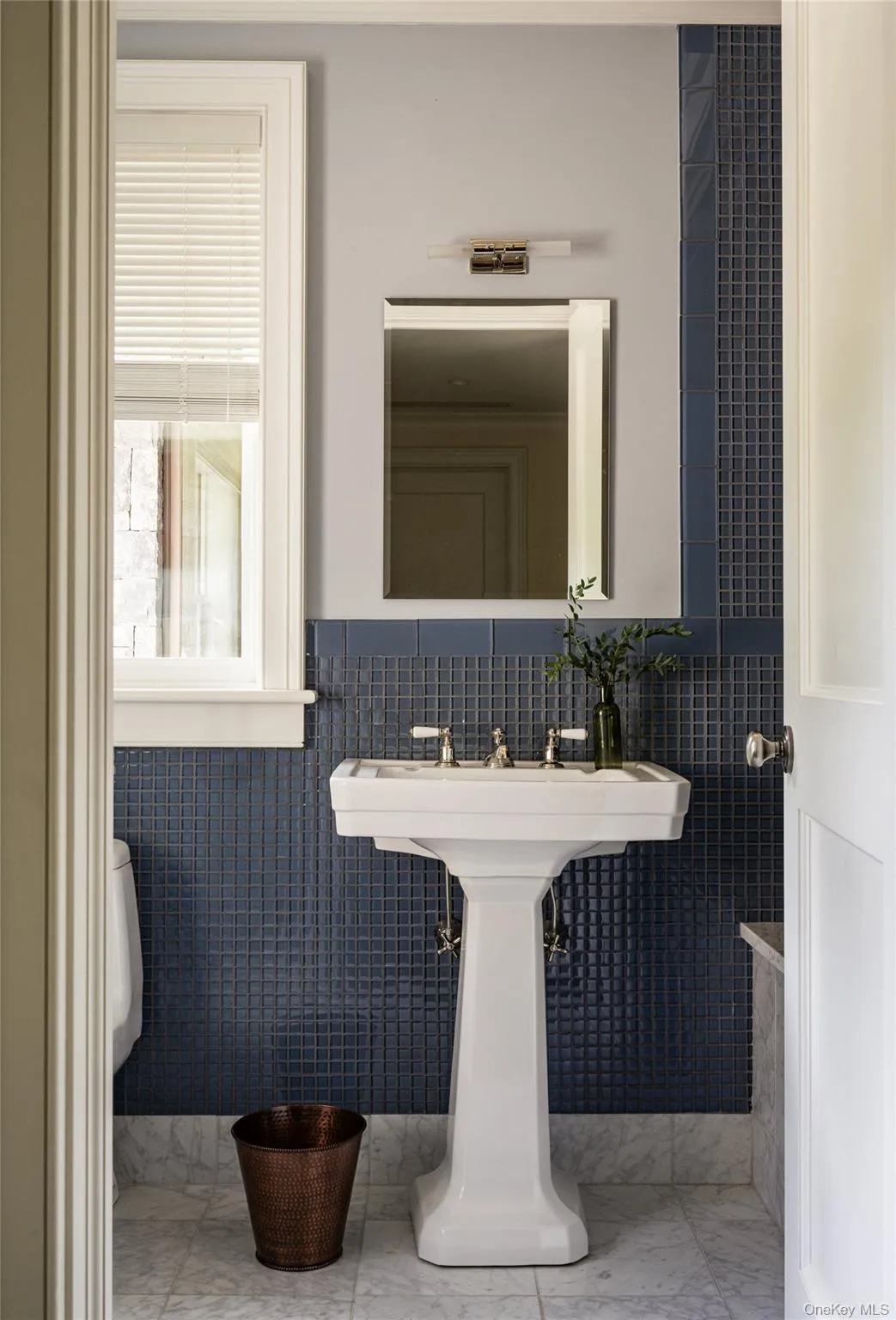 Bathroom featuring tile walls, wainscoting, and marble finish floors Bathroom featuring tile walls, wainscoting, and marble finish floors