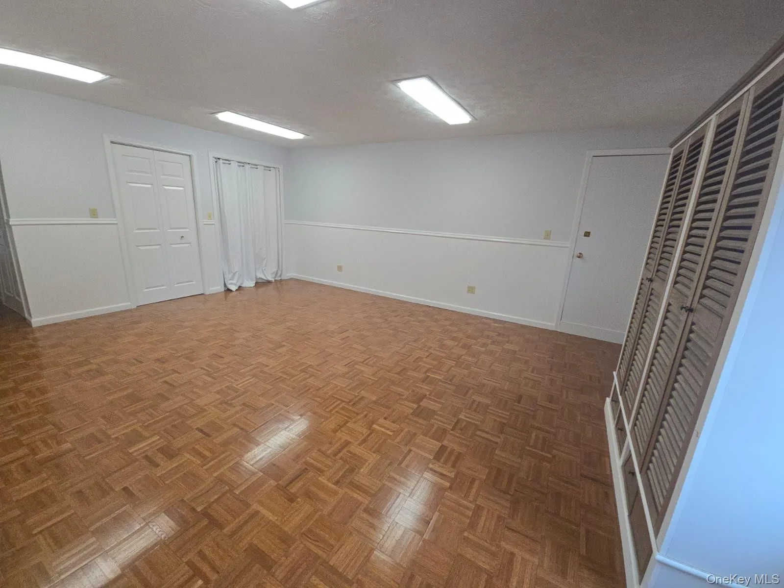 Unfurnished room with a textured ceiling and baseboards Unfurnished room with a textured ceiling and baseboards